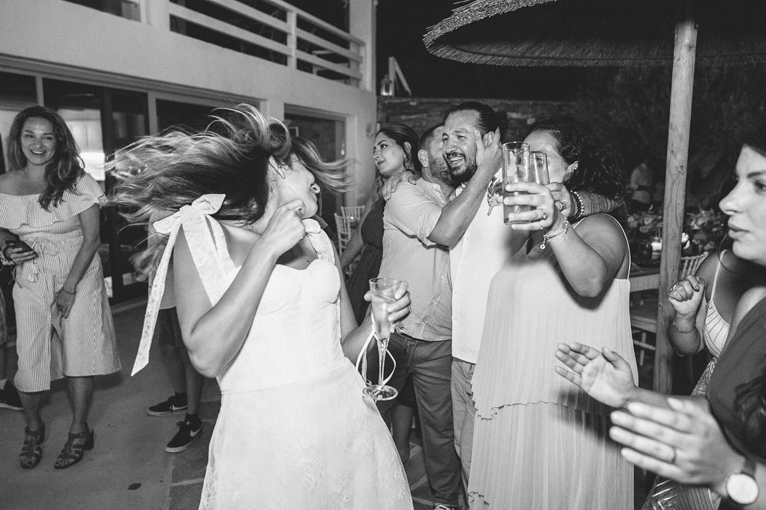 Bride Meli dancing enthusiastically with her friends in Paros