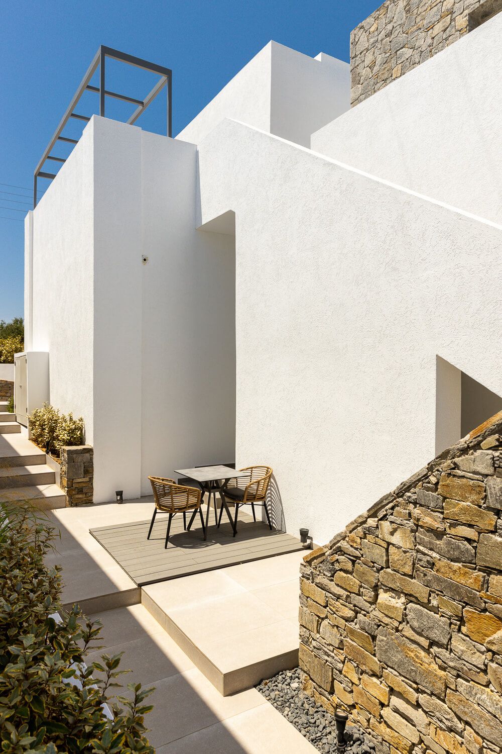 Modern white Cycladic architecture under clear blue sky in Parion Opus Hotel.