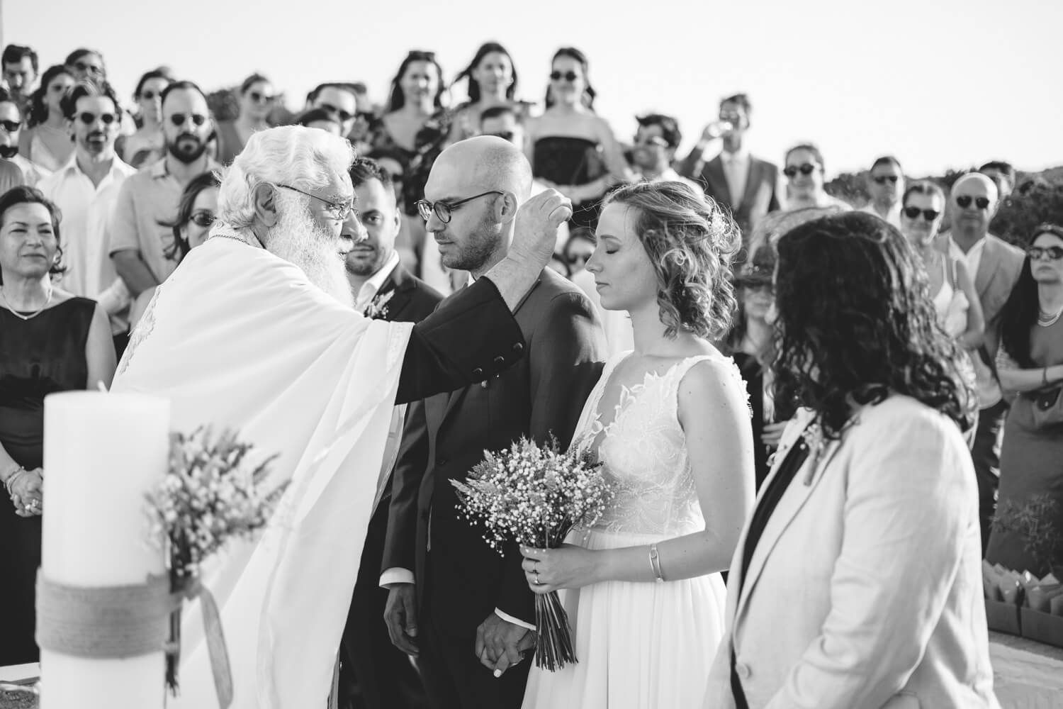 black and whithe shot of a Beautiful Orthodox wedding ceremony under the bright Aegean sun
