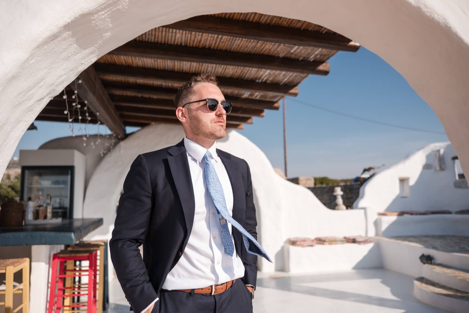 Groom Cody posing before his private villa wedding in Paros