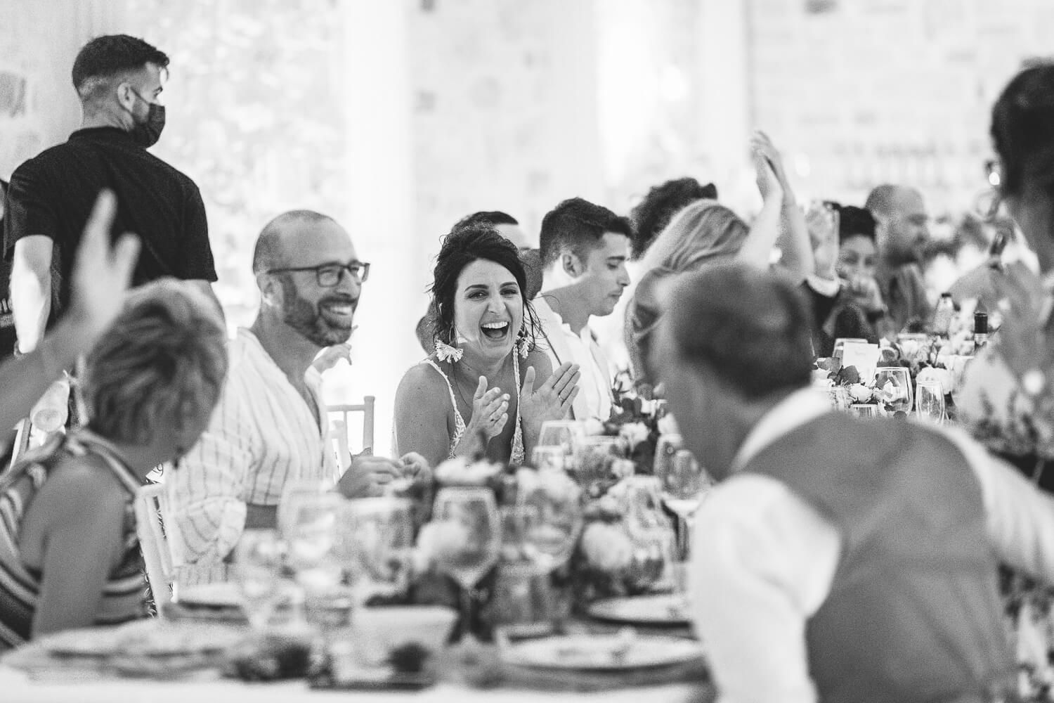 Candid shot of the guests laughing during the wedding speeches