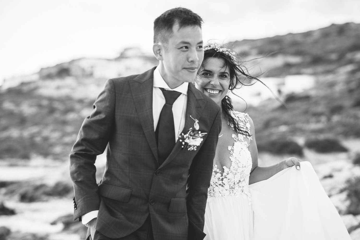 Couple walking on the beach after their wededing ceremony in Agios Georgios Antiparos