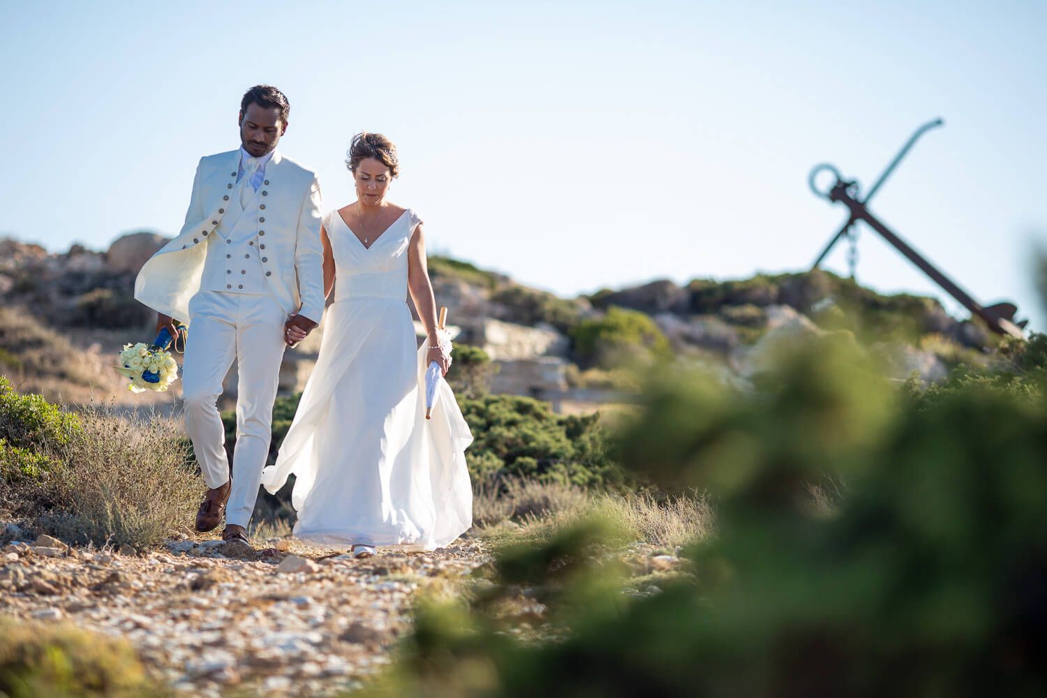 Newlyweds kissing in front of Pyrgaki chapeli in Paros Greece