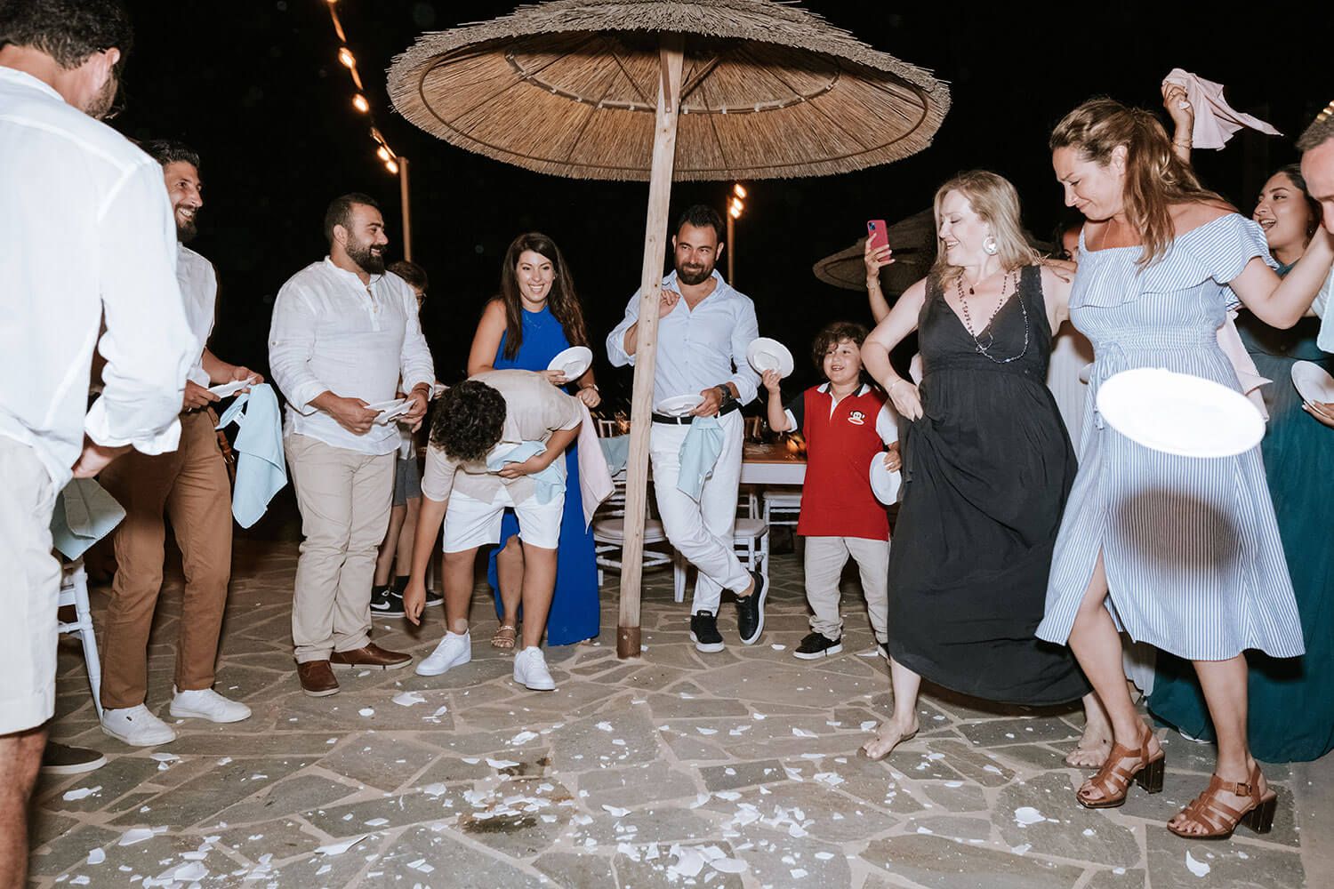 Bride and groom breaking plates during their authentic Greek wedding