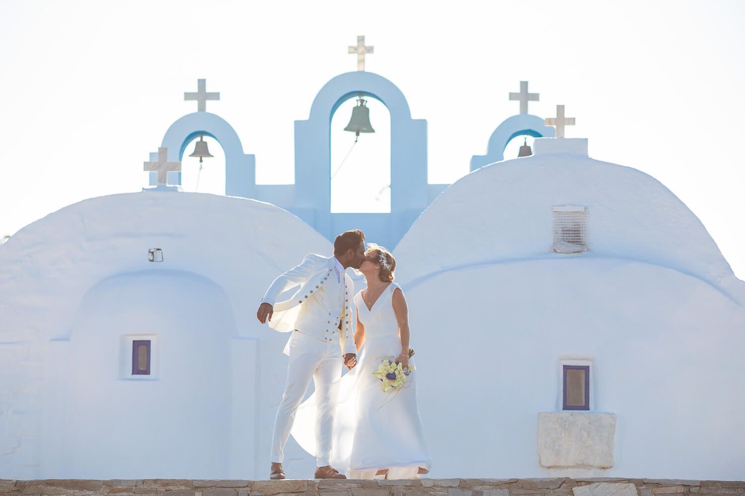 Couple kissing in front of Pyrgaki chapeli in Paros Greece