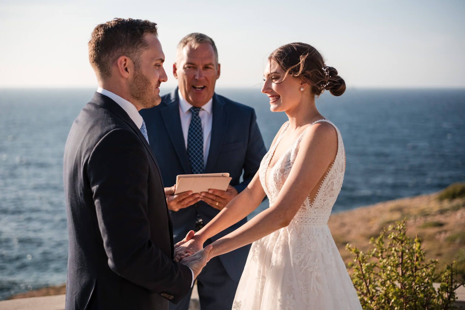 The couple holding hands during their private elopement in the Cyclades