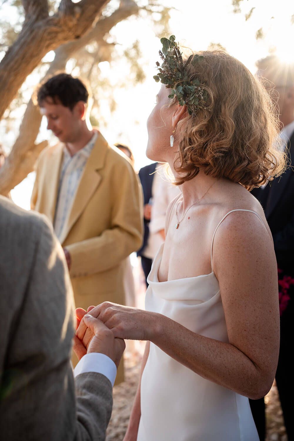Vanessa and Ali holding hands during their wedding  by the sea