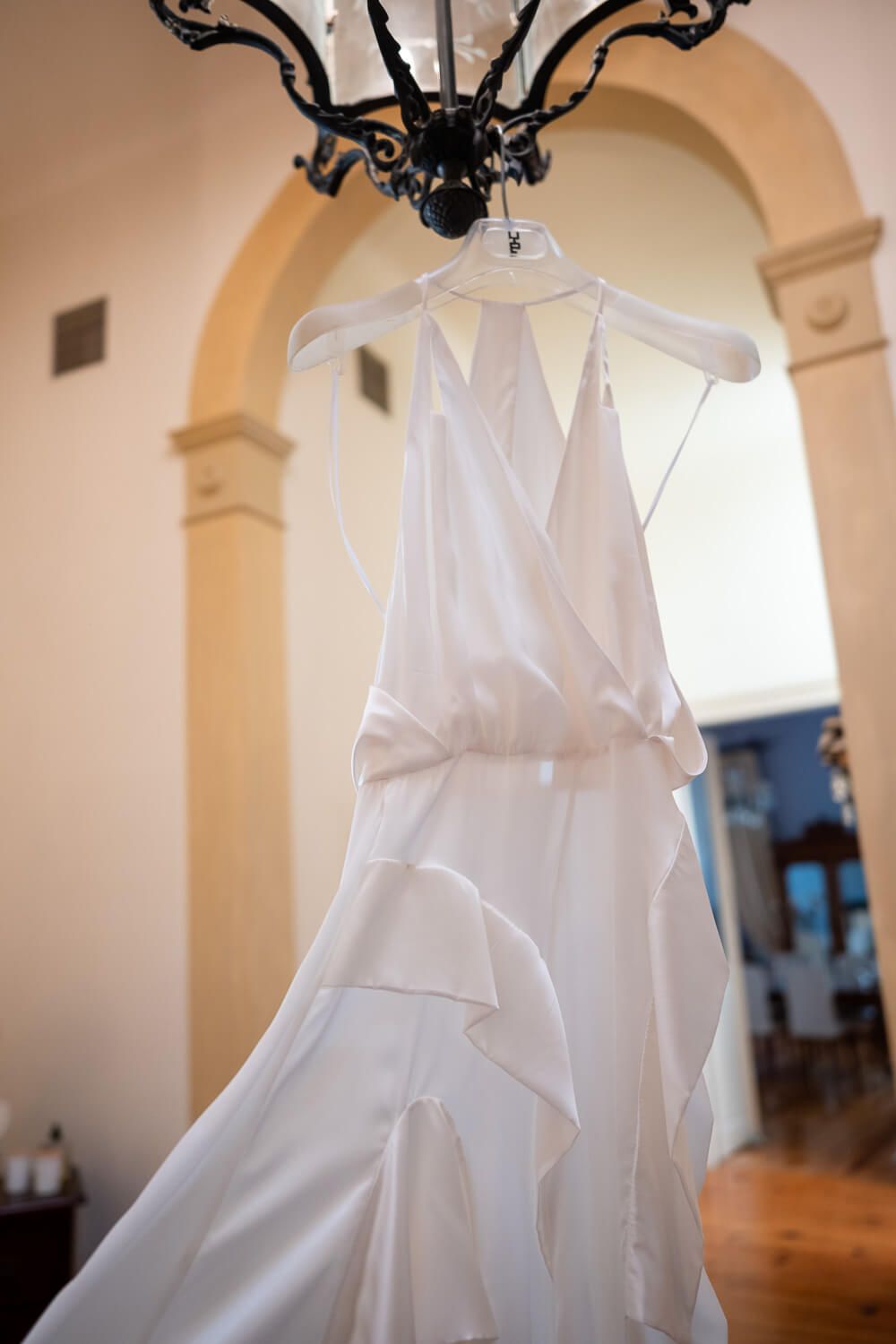 Elegant wedding dress hanging in a traditional Syros mansion