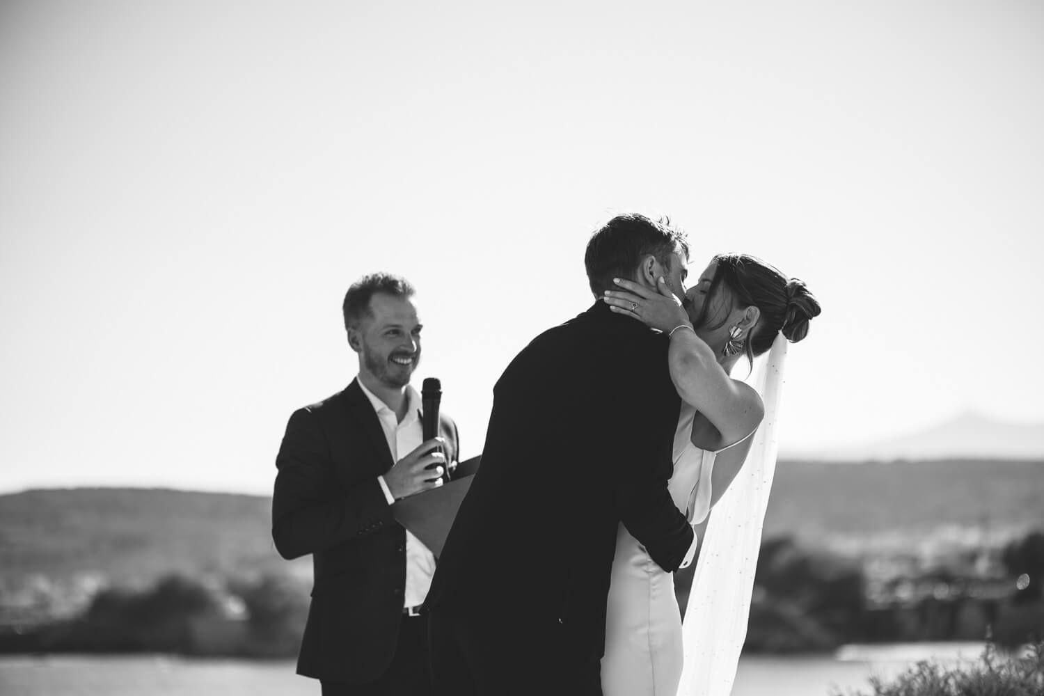 The couple sharing their first kiss as husband and wife by the sea