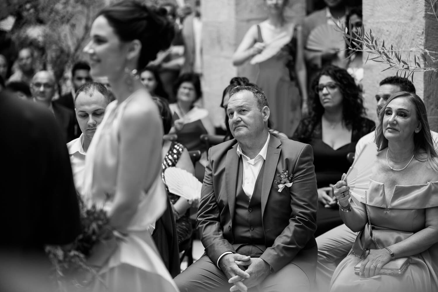 Wedding guests wiping away tears during an emotional ceremony
