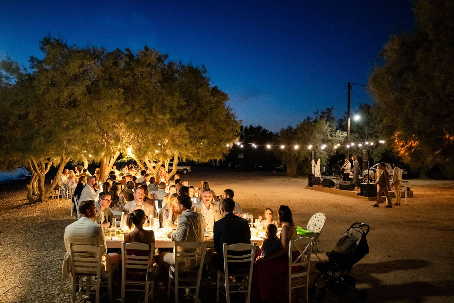 Romantic beachfront wedding reception illuminated by fairy lights in Paros
