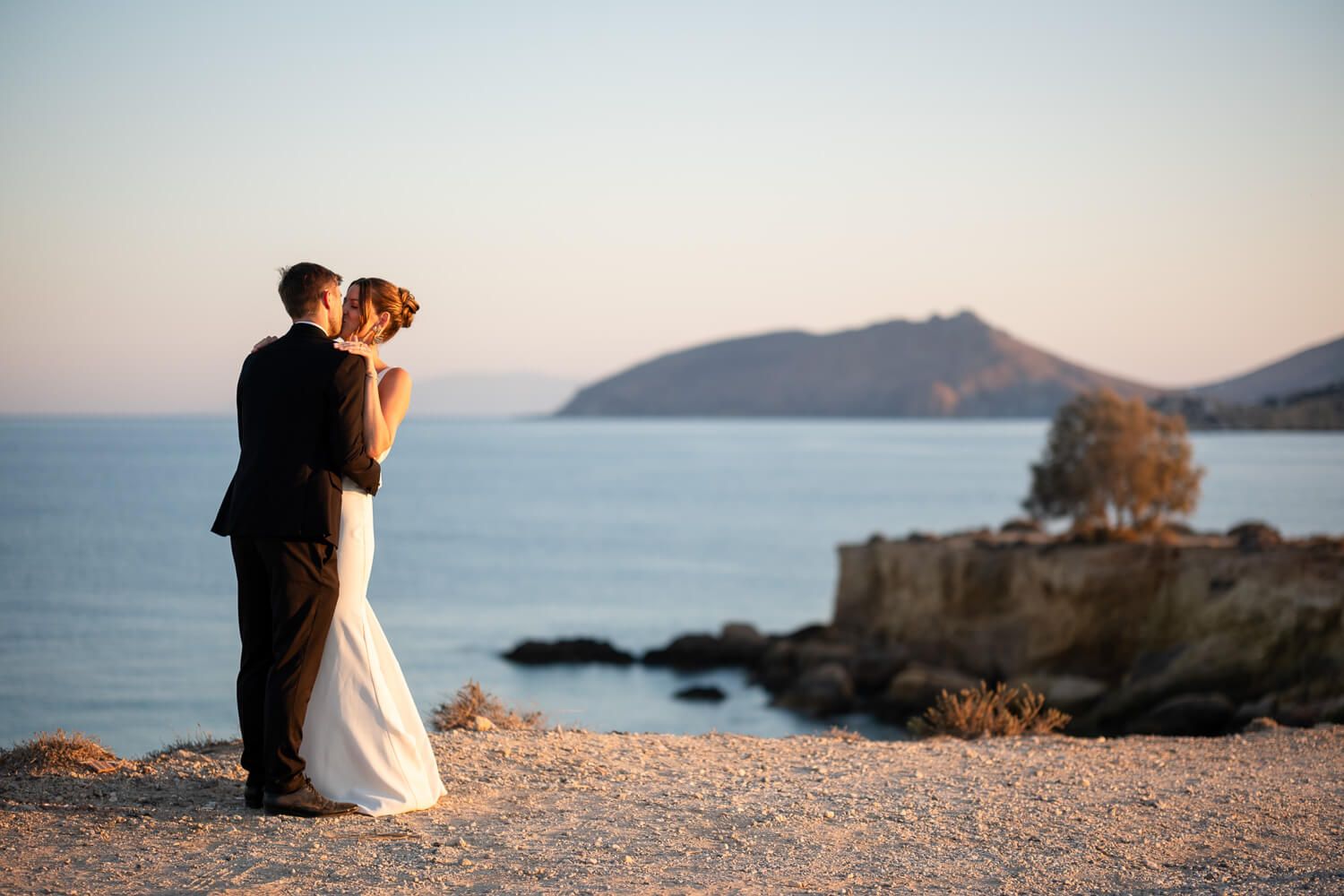 Jess and Daniel walking hand in hand during golden hour in Paros