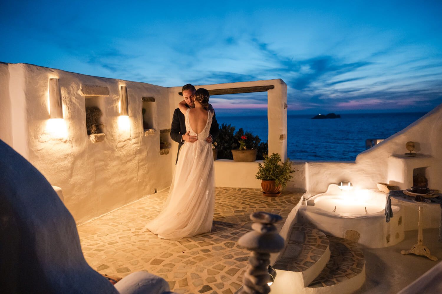 The couple sharing a romantic first dance by the illuminated pool