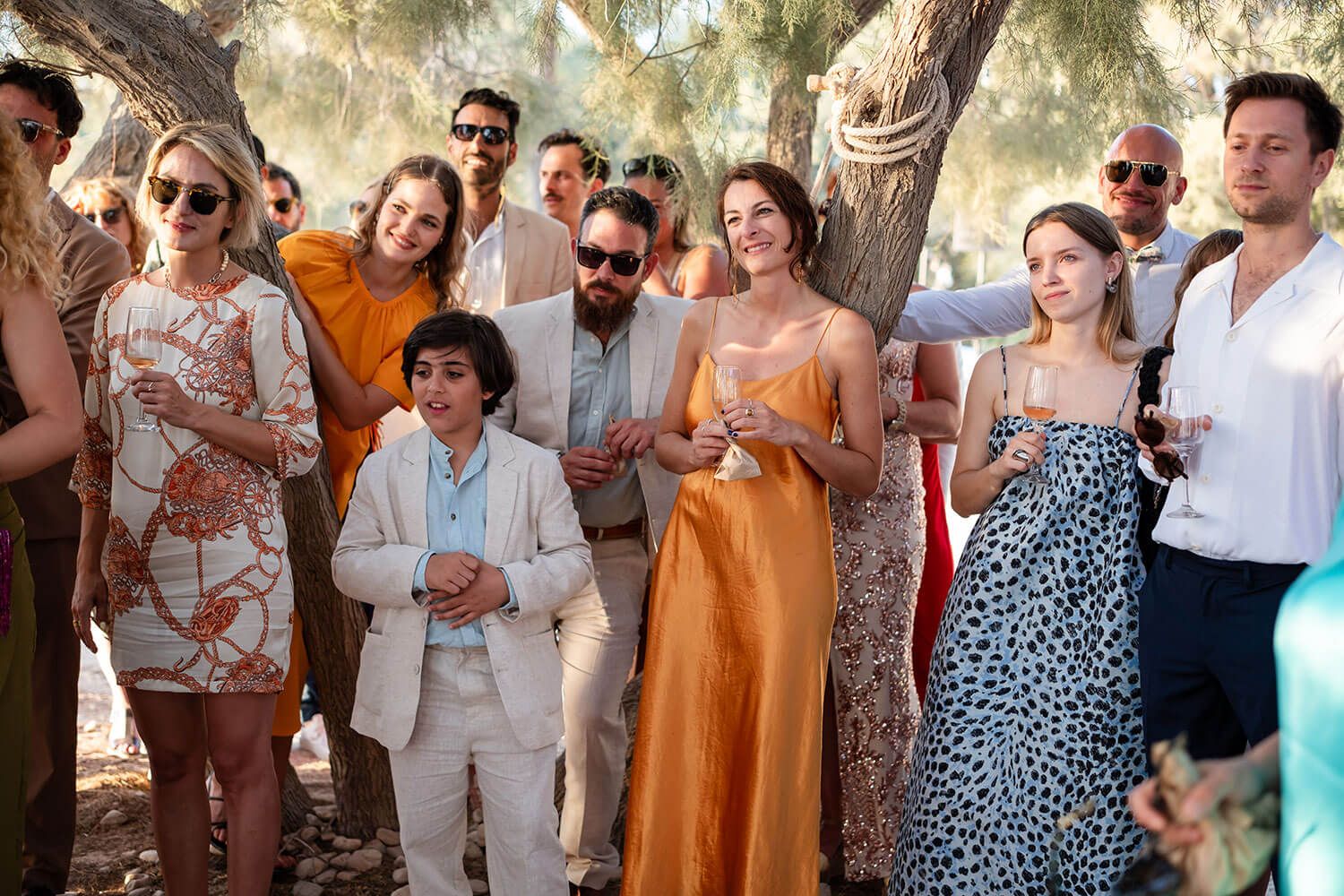 Wedding guests wiping happy tears during a seaside ceremony in Greece