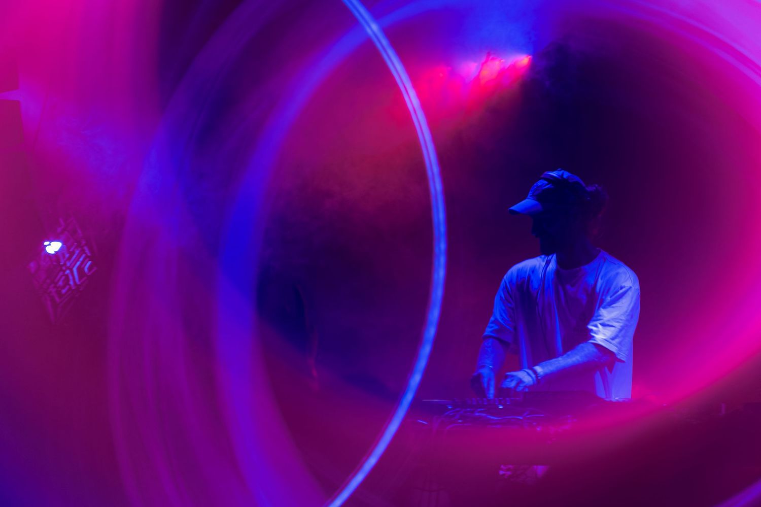 Sous les lumières de la scène à l’Anatha Fest à Montréal, un DJ joue sa musique devant le public.