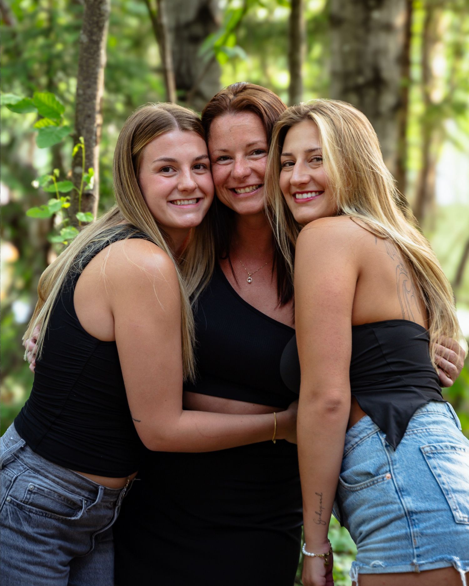 Maman souriante avec ses deux filles adolescentes posant dans le Sentier du Bonheur à Chibougamau.