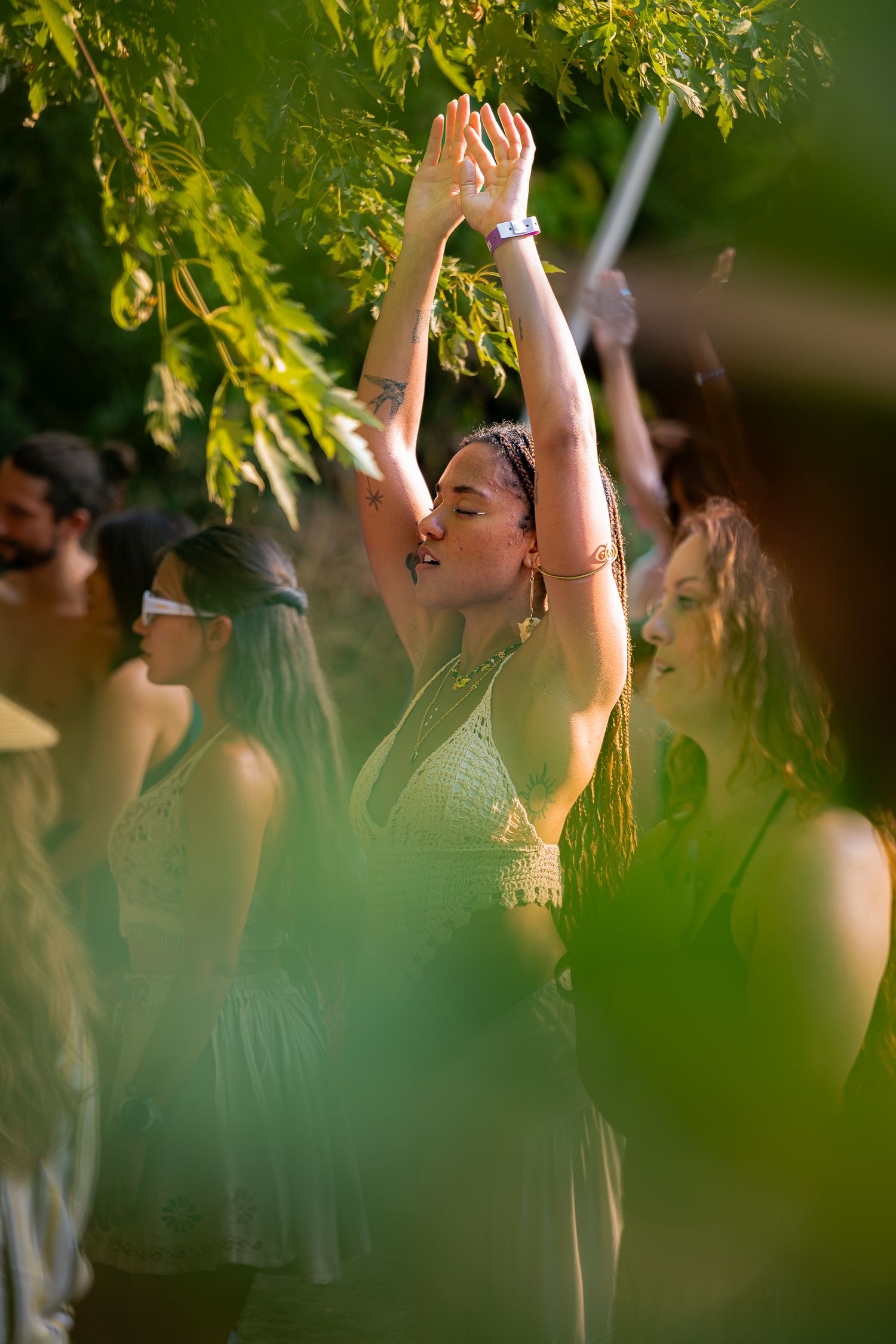 Femme dans son élément, méditant debout les bras levés vers le ciel à l’Anatha Fest à Montréal.