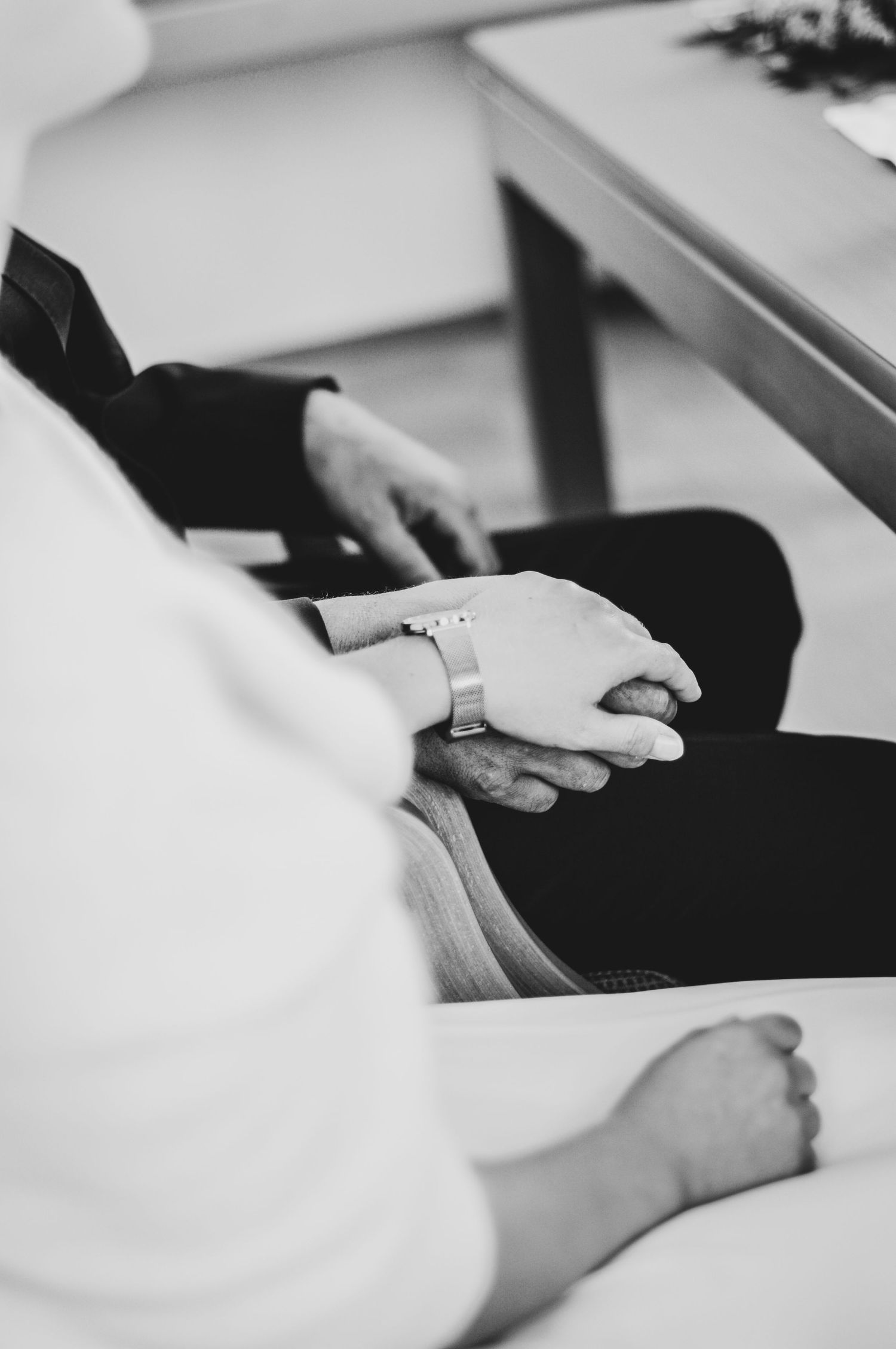 Schwarz-Weiß-Nahaufnahme von Händen eines Hochzeitspaares im Standesamt bei einer Landhochzeit.