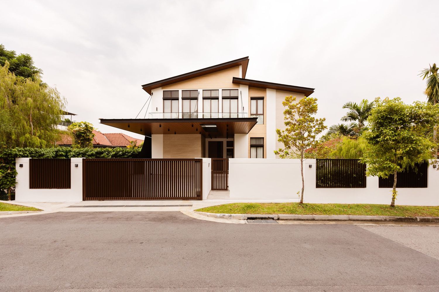A panoramic view shows a curved driveway leading to a modern house with white walls and brown trim.
