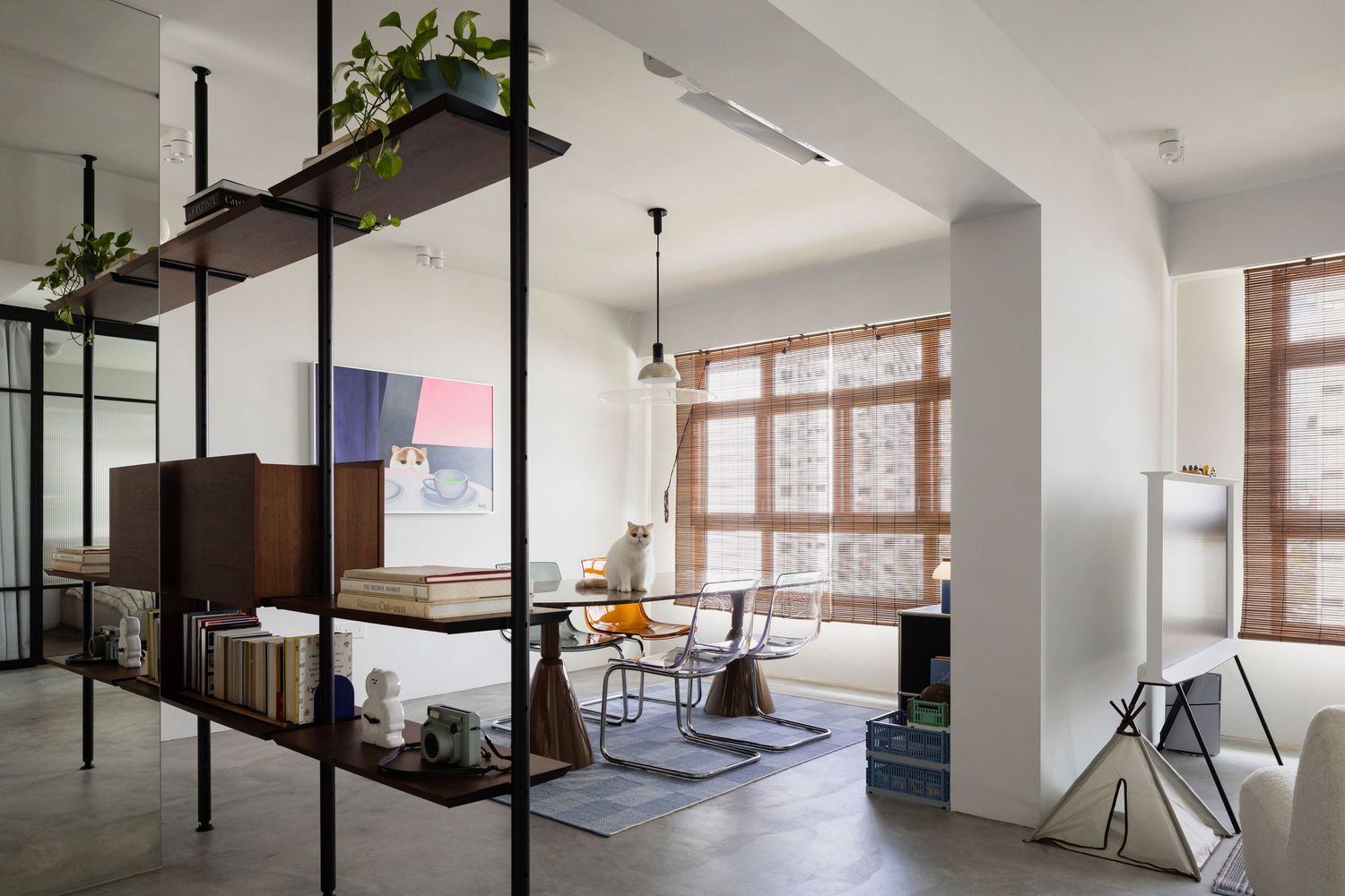 Modern open office space with industrial black columns, white walls, and large windows providing natural light.