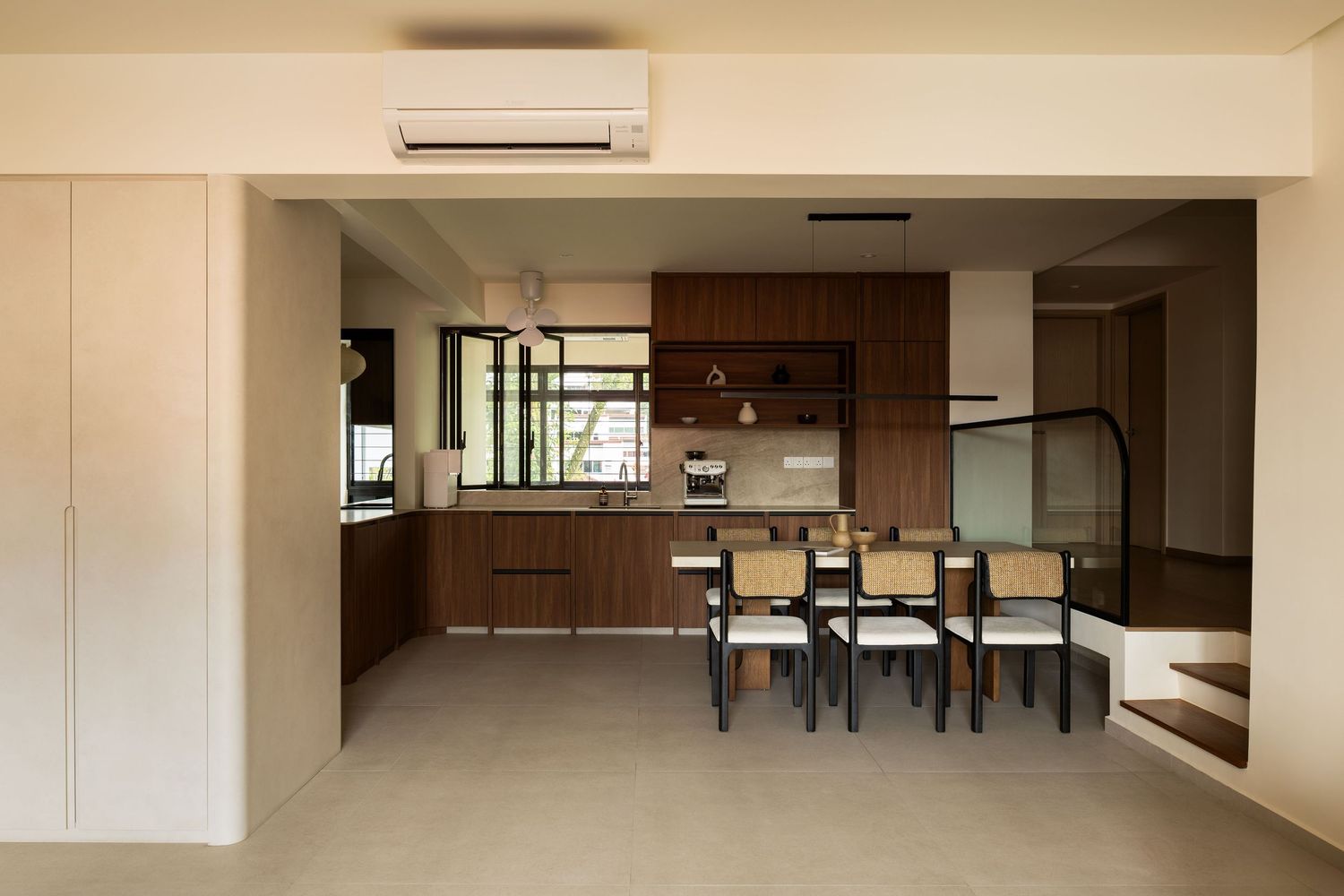 Modern open concept dining area with wooden kitchen cabinets and wall-mounted air conditioning unit in minimalist space.