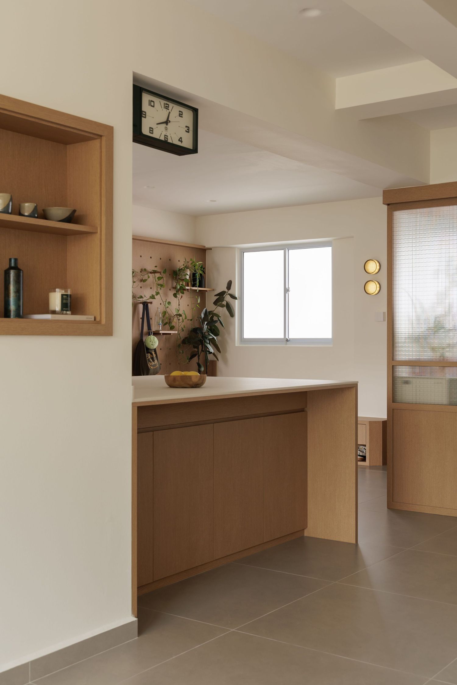 Modern minimalist interior with wooden built-in shelving and cabinets featuring clean lines and neutral tones.