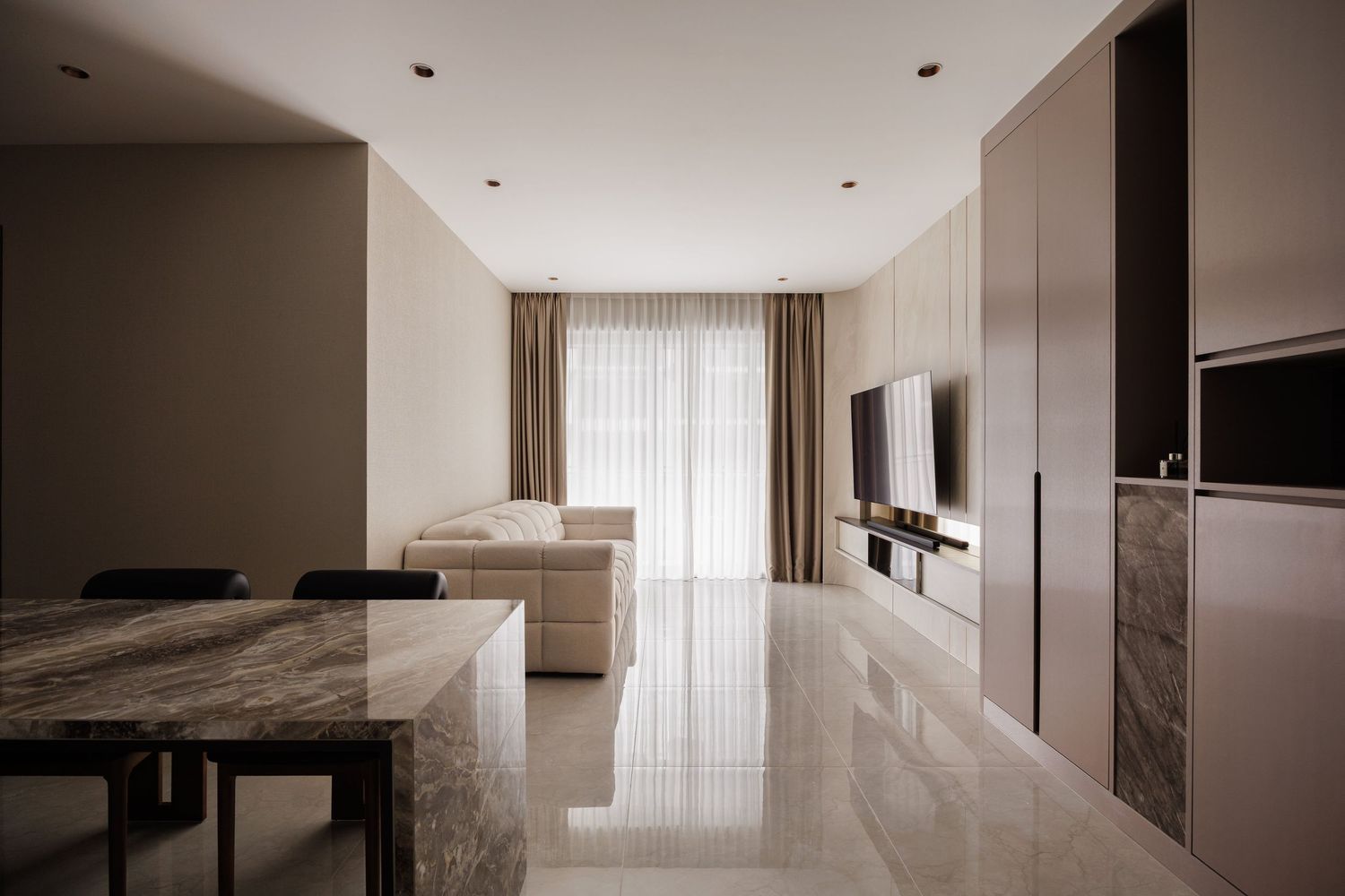 Modern minimalist bedroom interior with neutral tones, recessed lighting, and floor-to-ceiling windows.