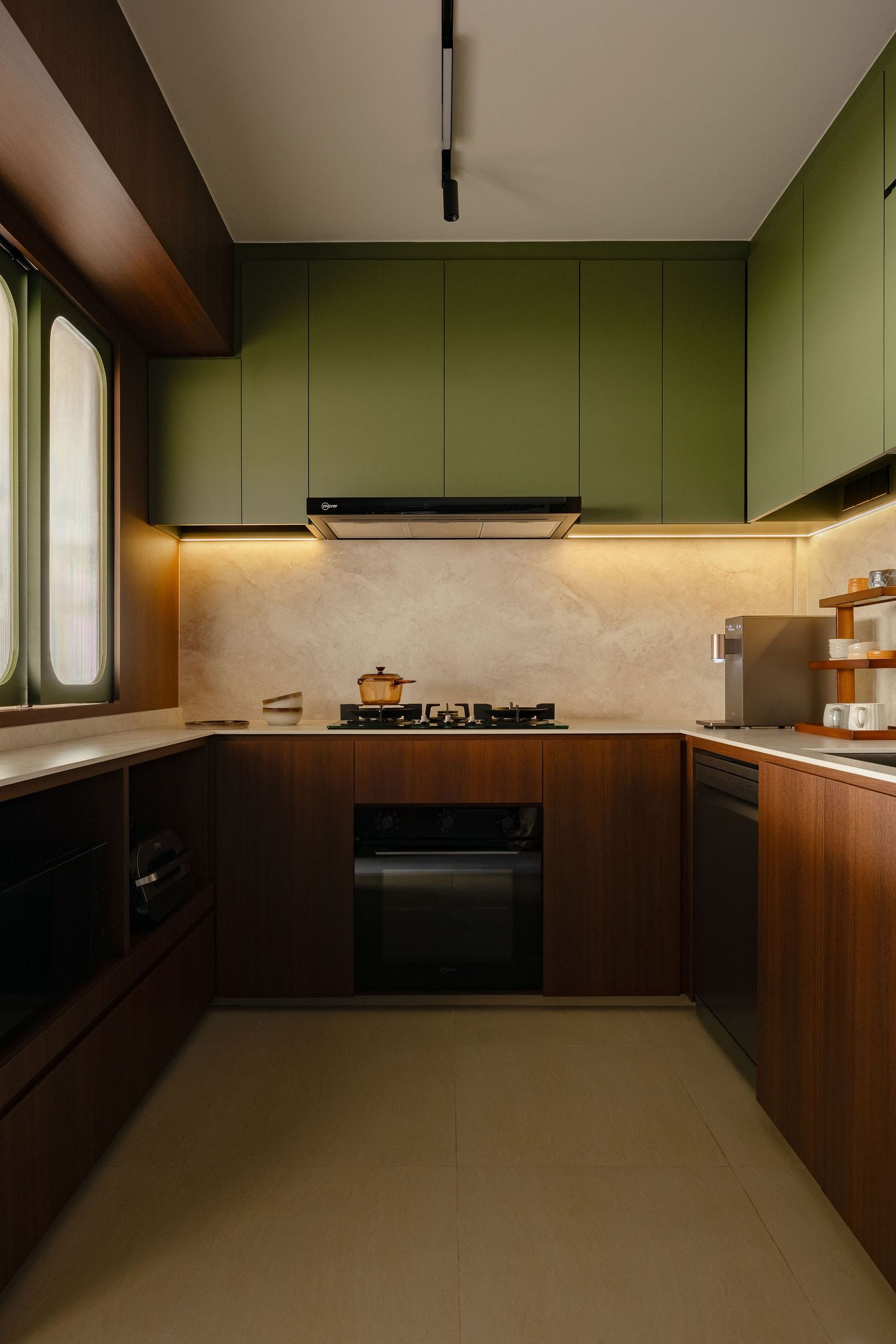 Modern U-shaped kitchen with sage green upper cabinets, walnut wood lower cabinets, marble backsplash, gas hob and built-in oven.
