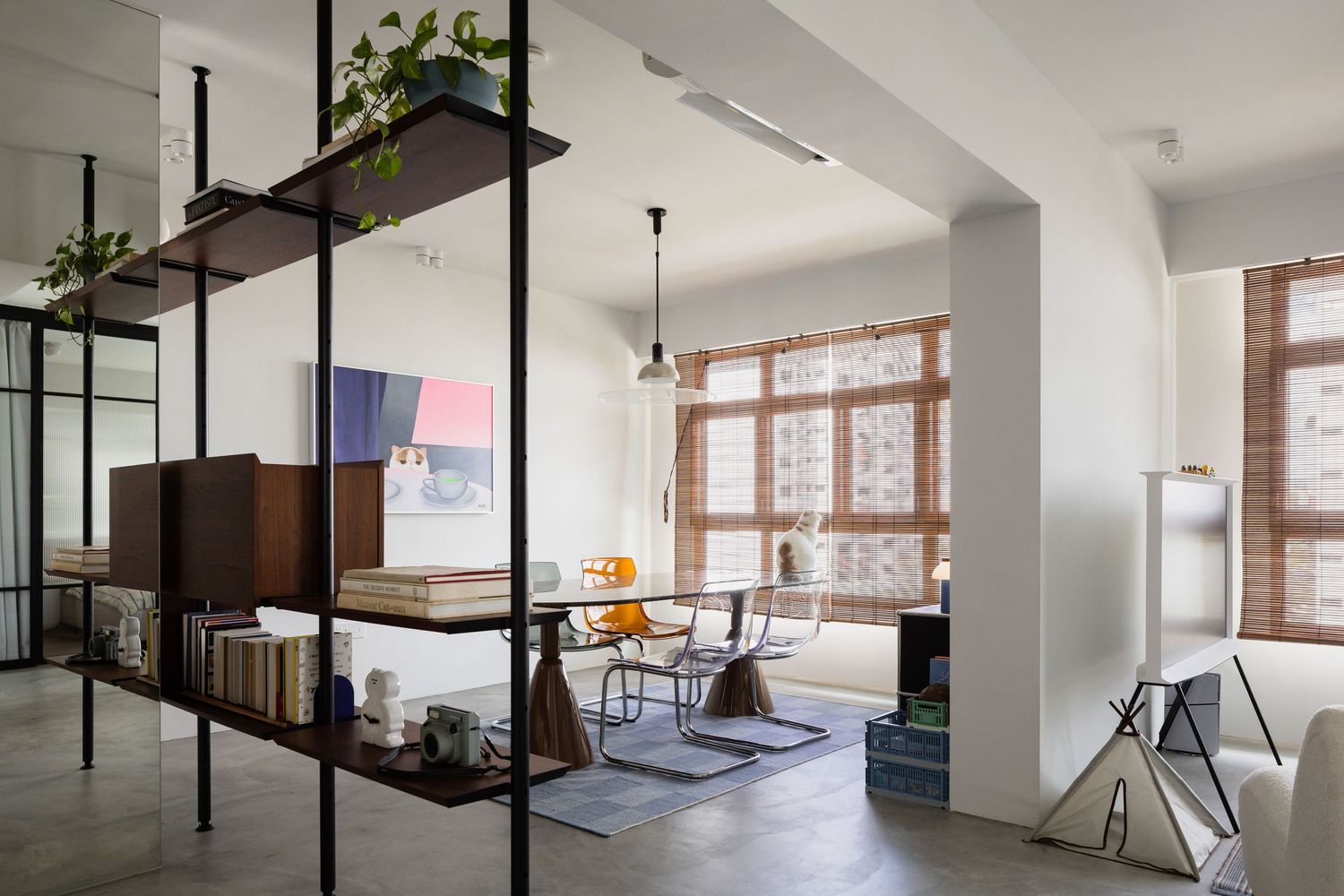 Modern loft interior with open metal shelving, concrete floors, brick windows, and minimalist dining area with plants.