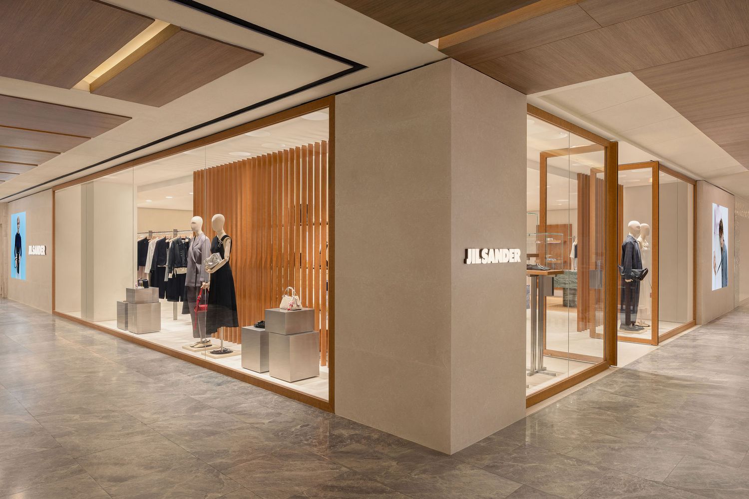 Jil Sander luxury fashion boutique interior with minimalist design, wooden accents, and elegant clothing displays.