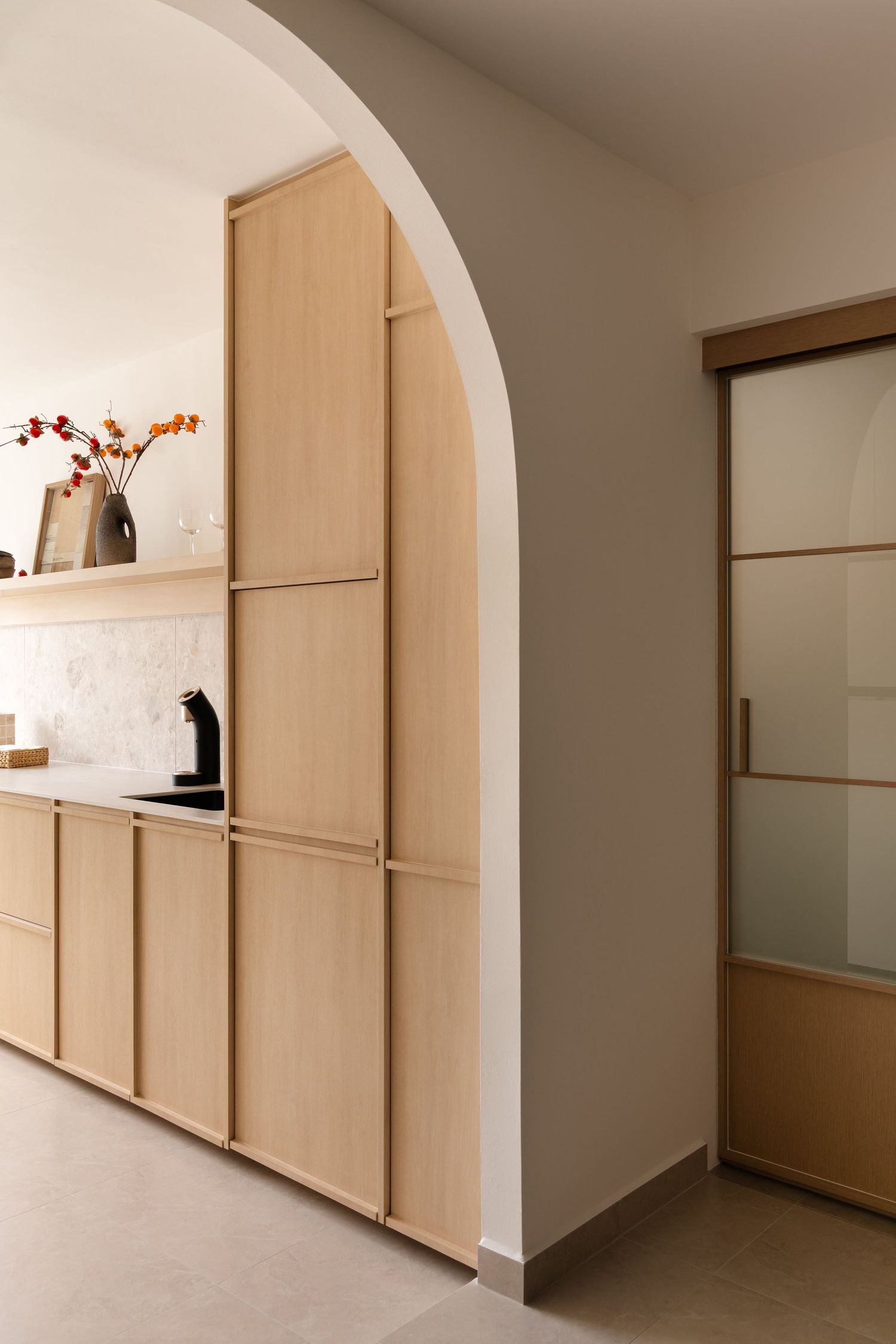 Modern minimalist interior hallway with light wood built-in storage cabinets and white walls creating a clean aesthetic.