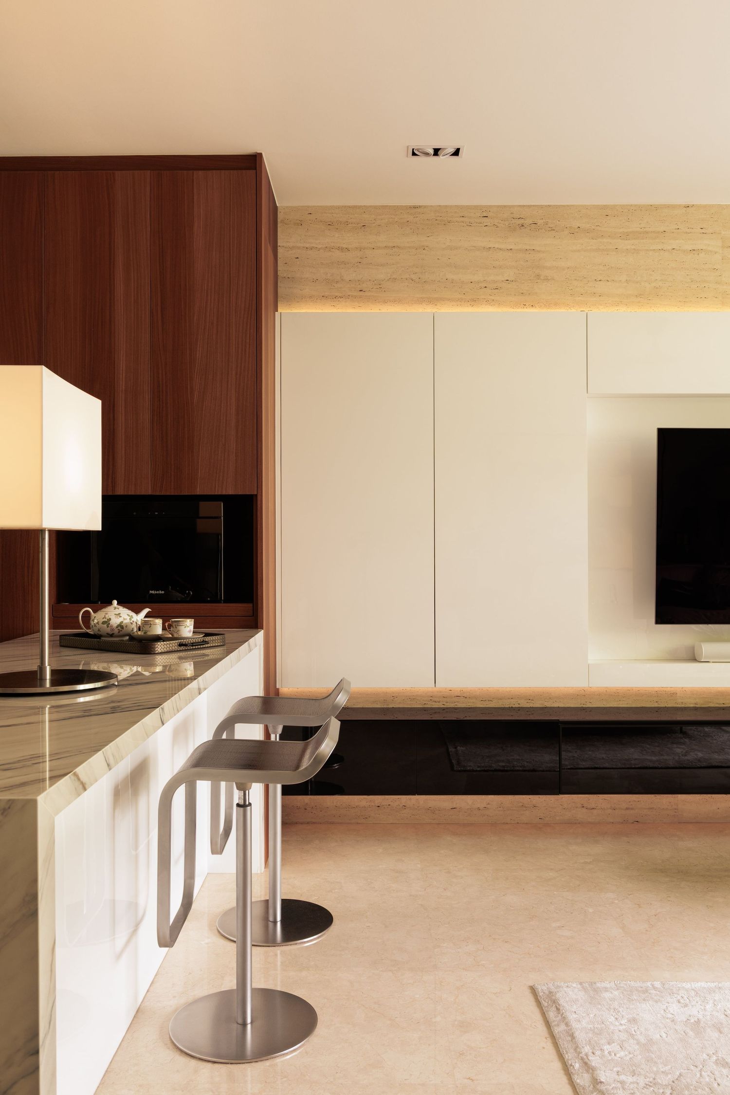 Minimalist modern interior space with sleek built-in cabinets and white walls illuminated by ambient lighting.