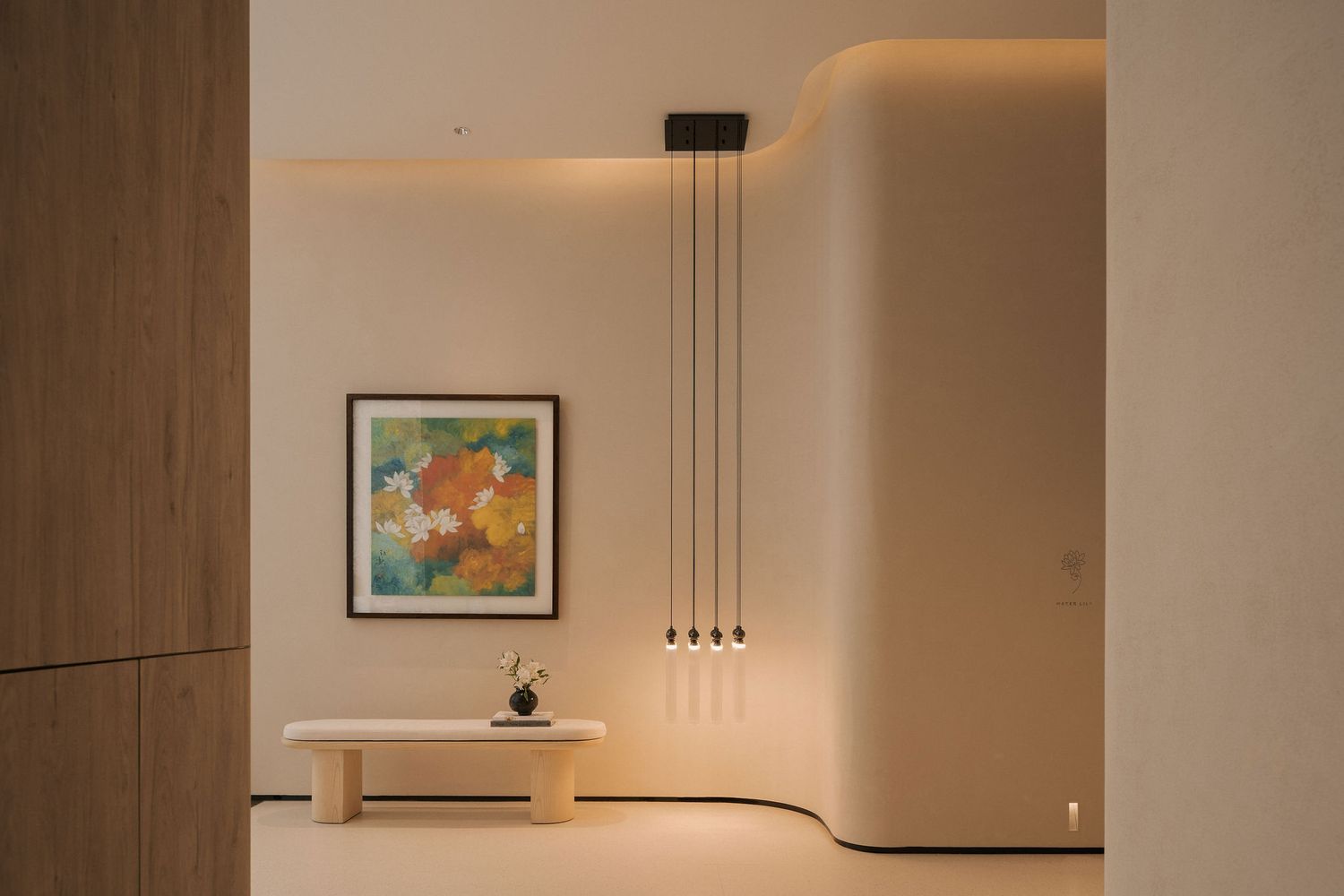 Modern minimalist hallway with warm lighting, abstract artwork, and elegant pendant lights above a sculptural console table.