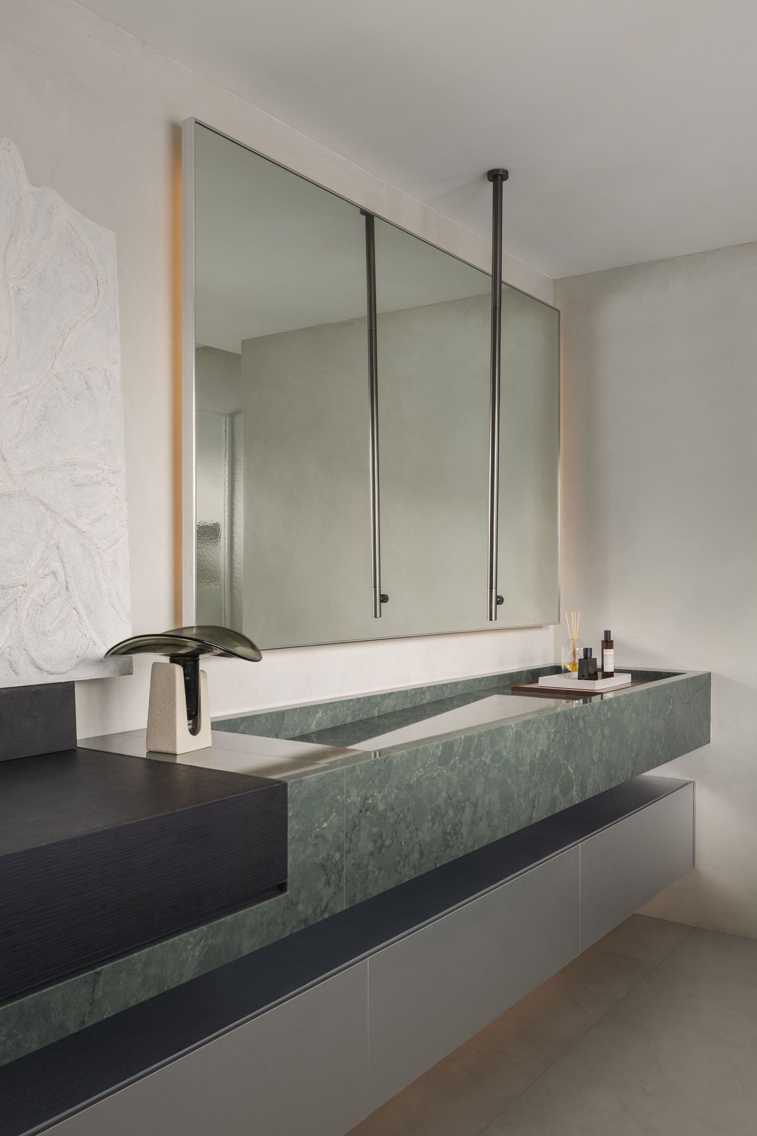 Modern bathroom with green marble double sink vanity, large mirror, and minimalist decor in neutral tones.