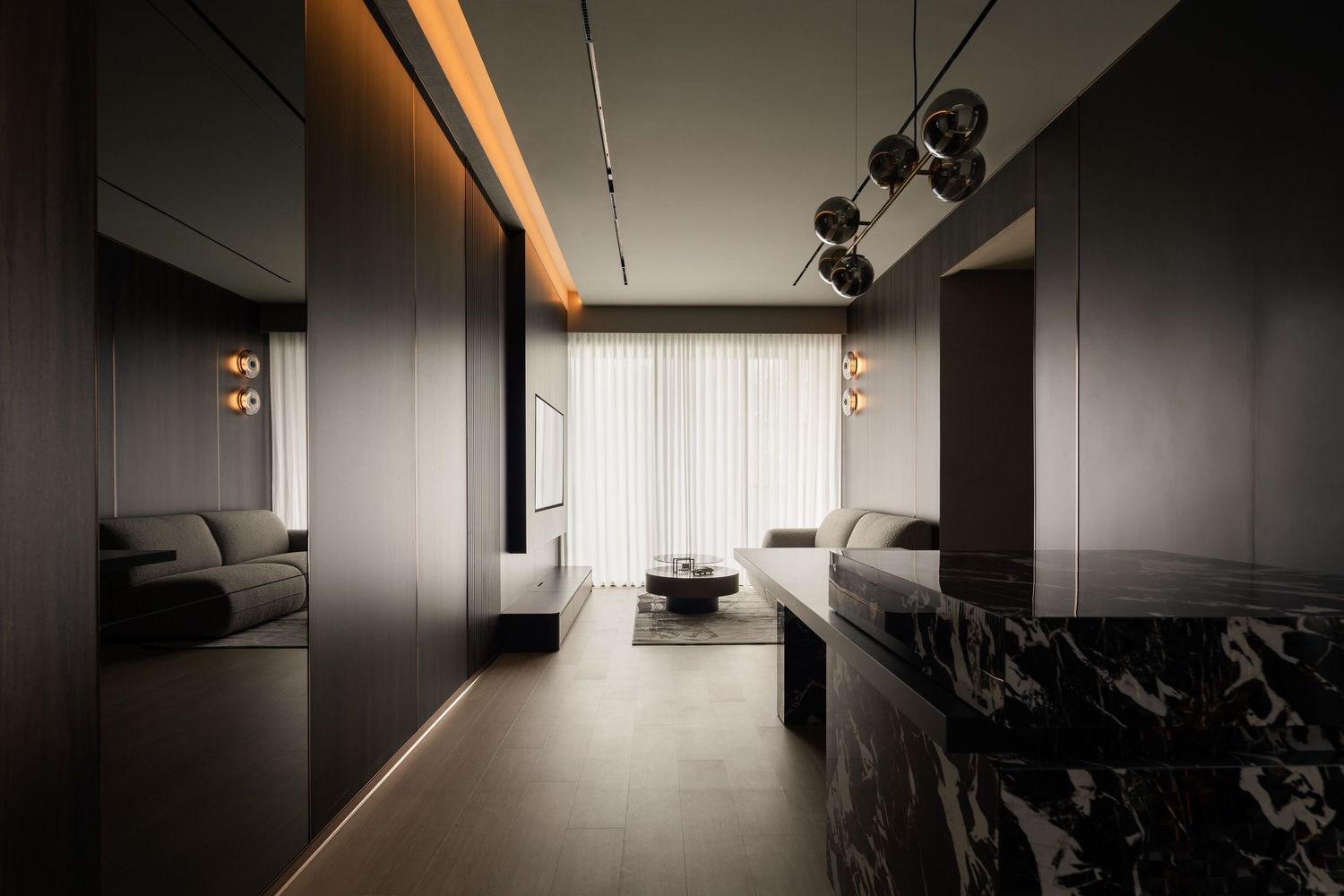 Sleek modern living room with dark wood paneling, marble countertop, pendant lights, and sheer white curtains.