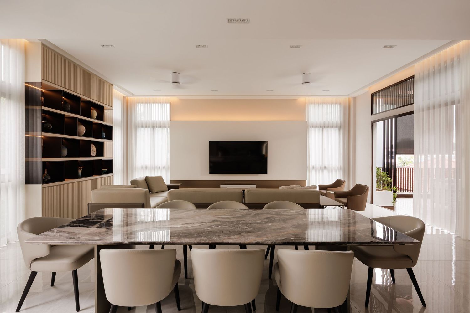 Elegant white modern dining room with long table, cream chairs, and contemporary pendant lighting over glossy floor.