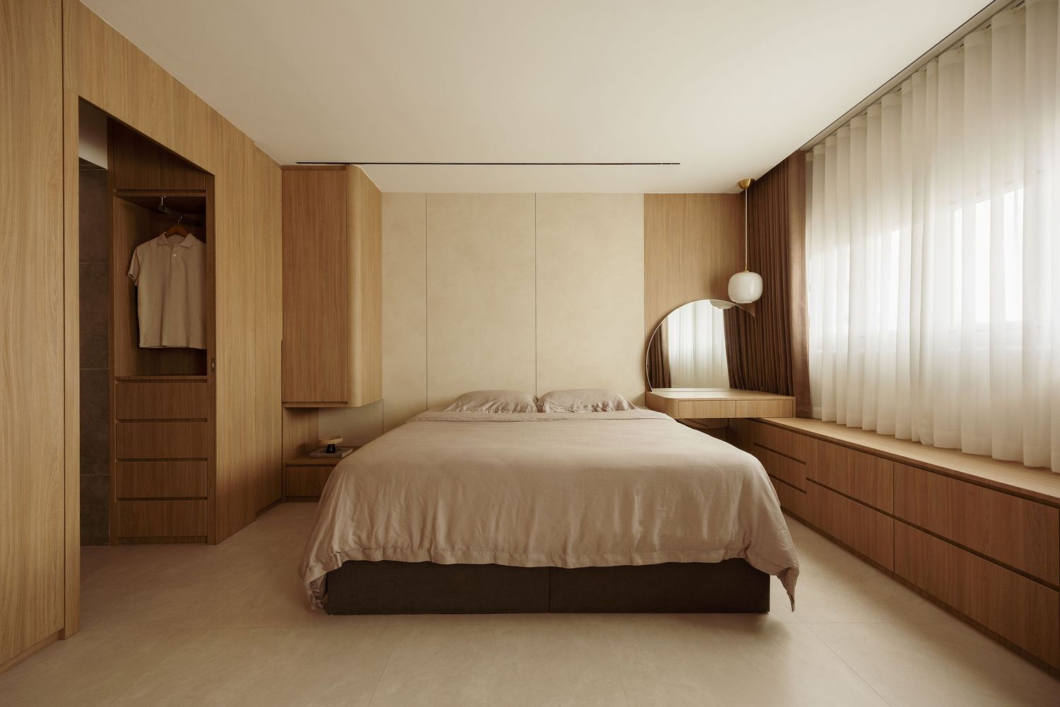 Minimalist bedroom with warm wood-paneled walls, built-in wardrobe, low-profile bed, and sheer curtains in neutral tones.