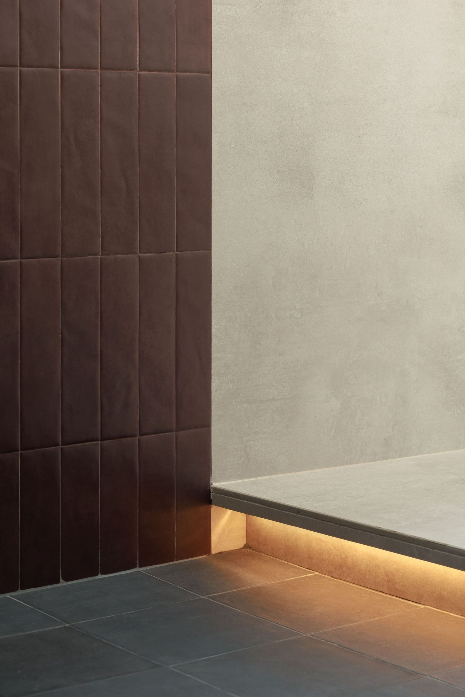 A series of architectural detail shots showing dark tiled walls with subtle lighting effects along the baseboards.