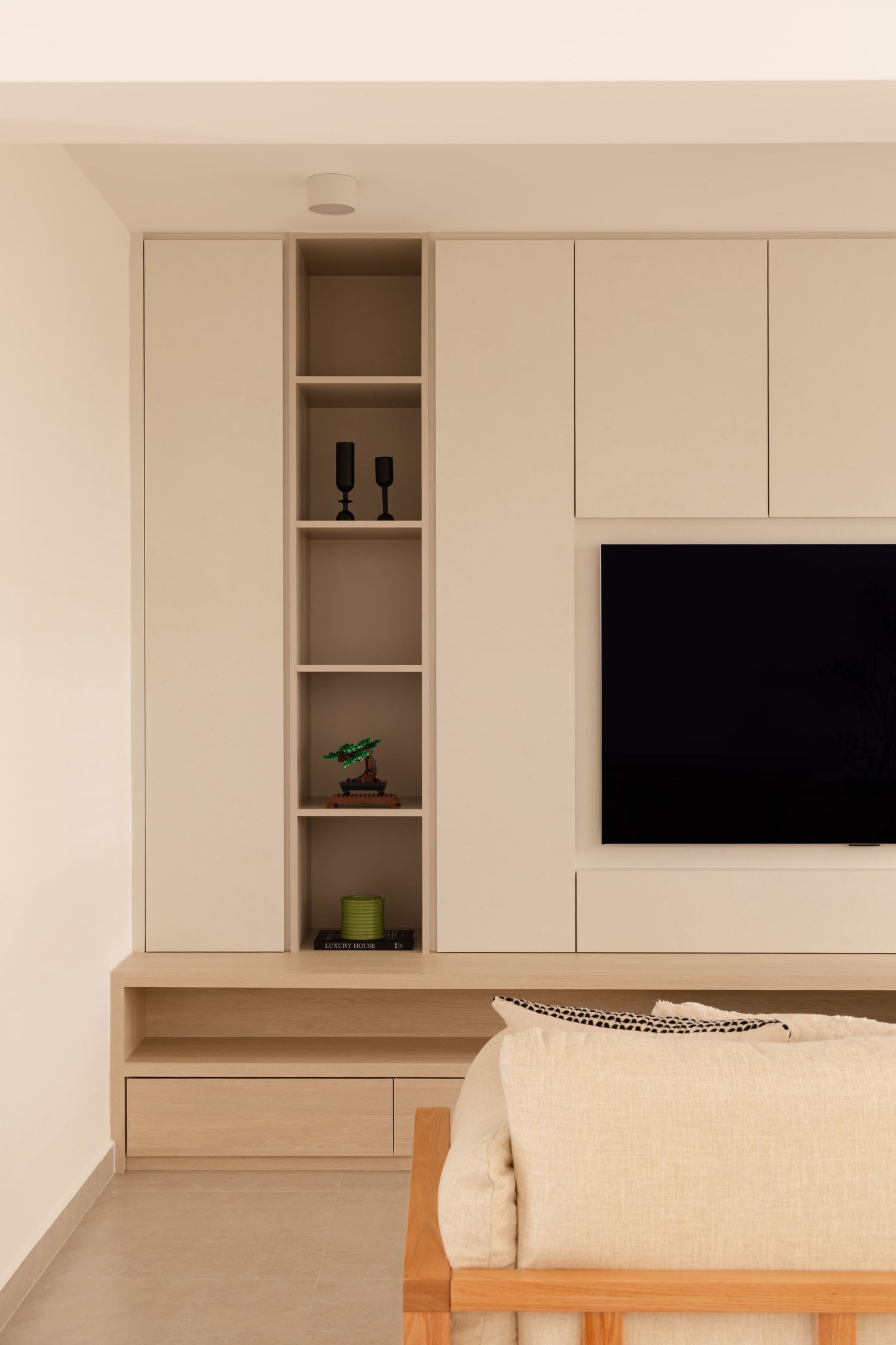 Modern white kitchen cabinets with open shelving and built-in storage display minimal decor against cream walls.