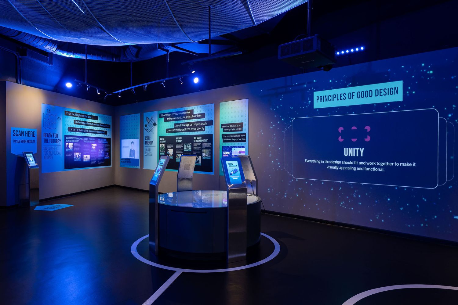 Interactive museum exhibit showcasing Principles of Good Design with glowing blue displays and touchscreen kiosks.
