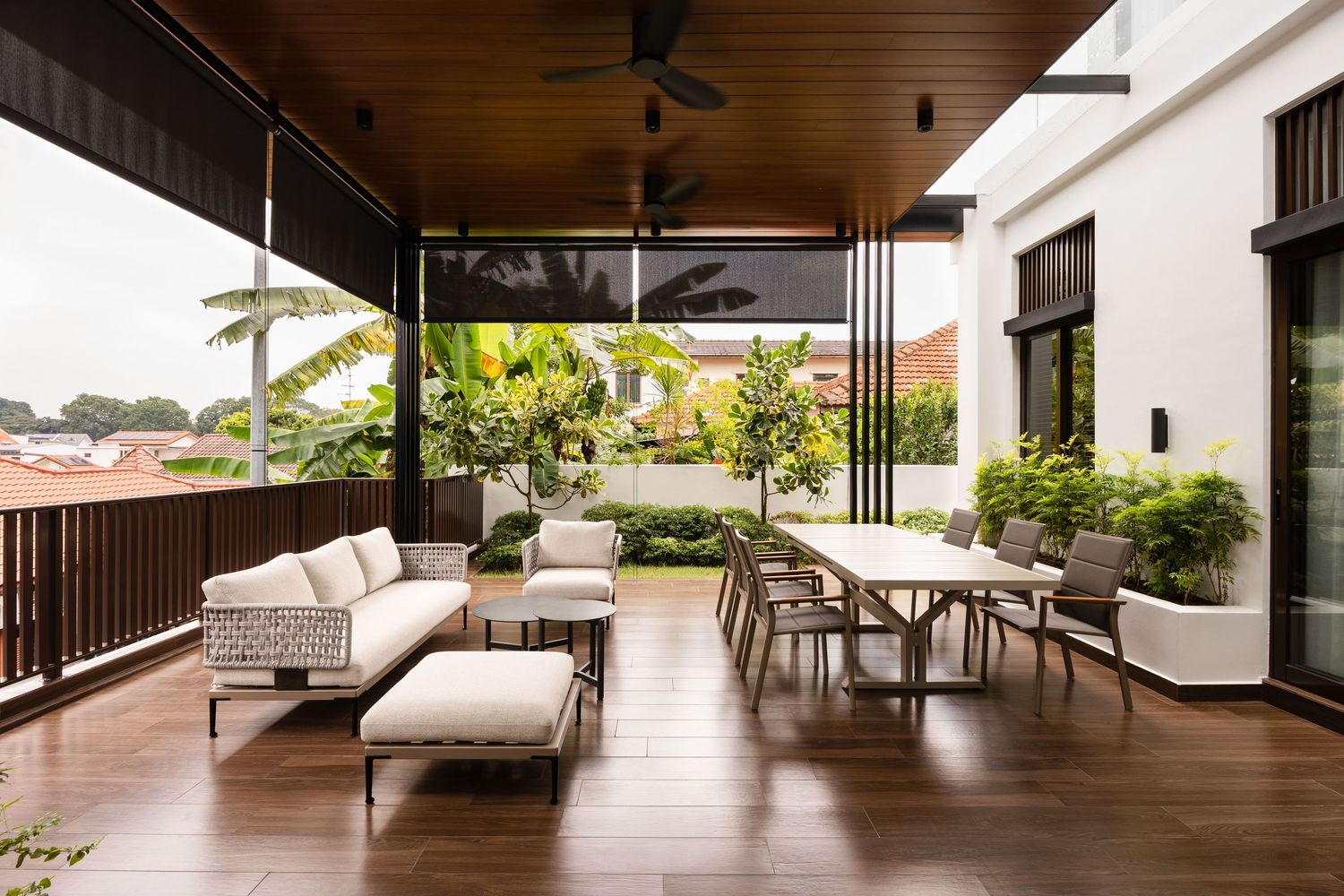 Contemporary open-concept beach house with dark wood slats and white cushioned furniture offers panoramic ocean views.