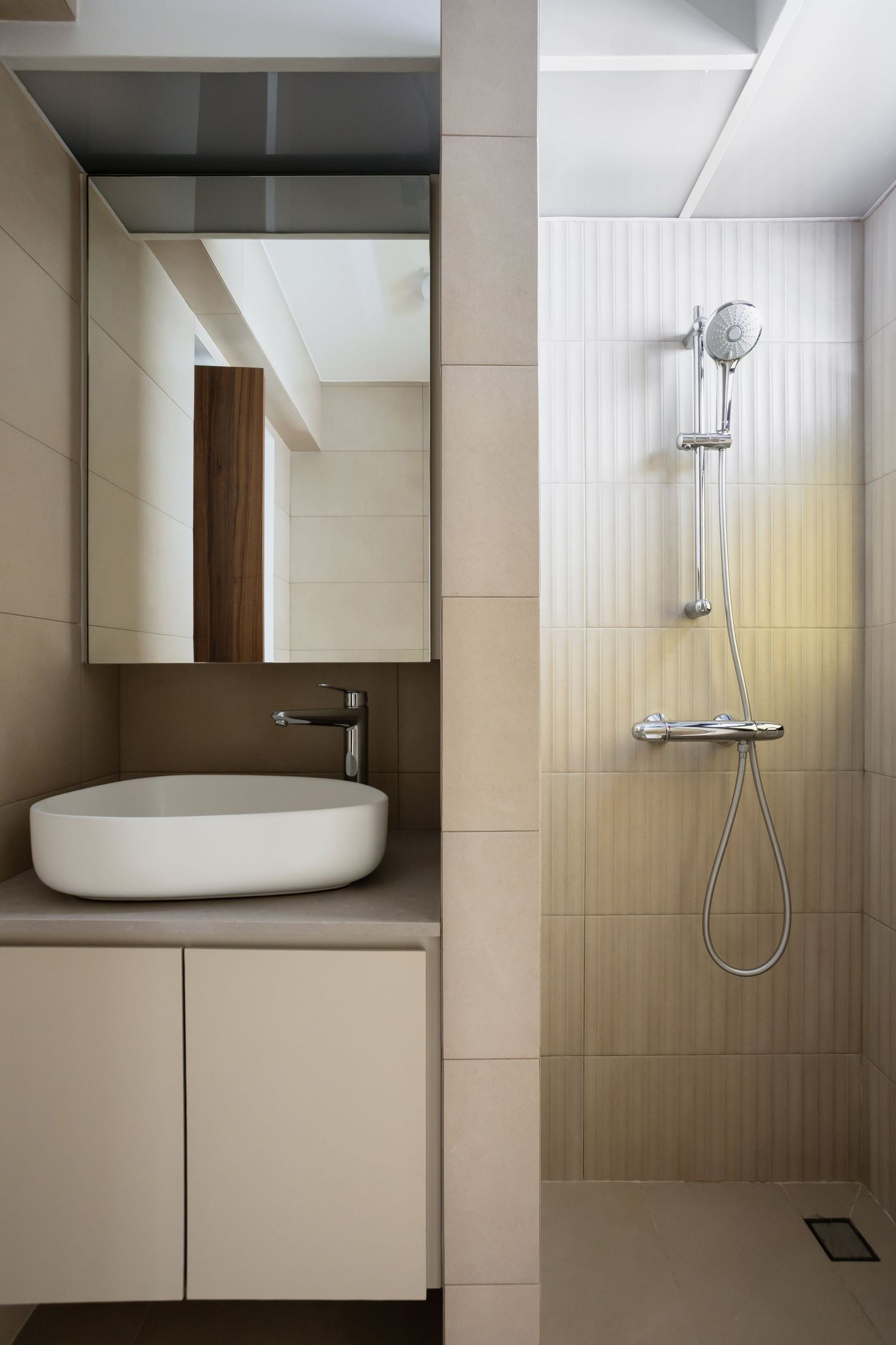 Modern minimalist bathroom interior with beige tiles, wooden accents, and white fixtures showing various angles of shower area.