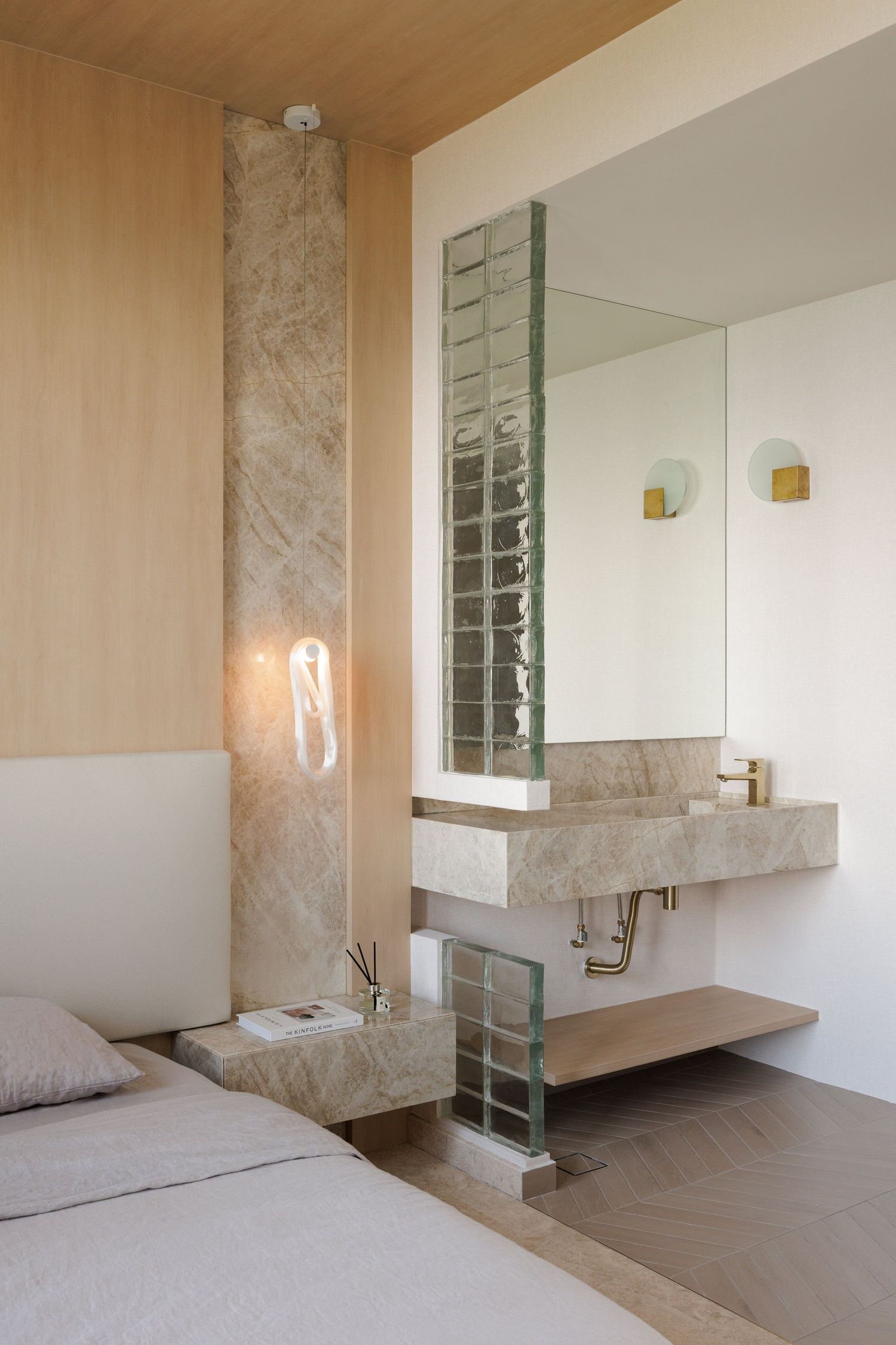 Interior shots of a minimalist bathroom design with marble walls, wooden ceiling and glass block windows.
