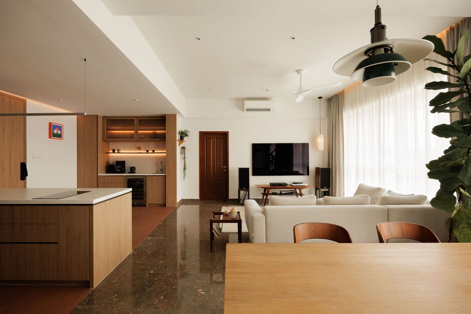 Modern open concept apartment interior with wooden kitchen cabinets, living area and natural light from large windows.