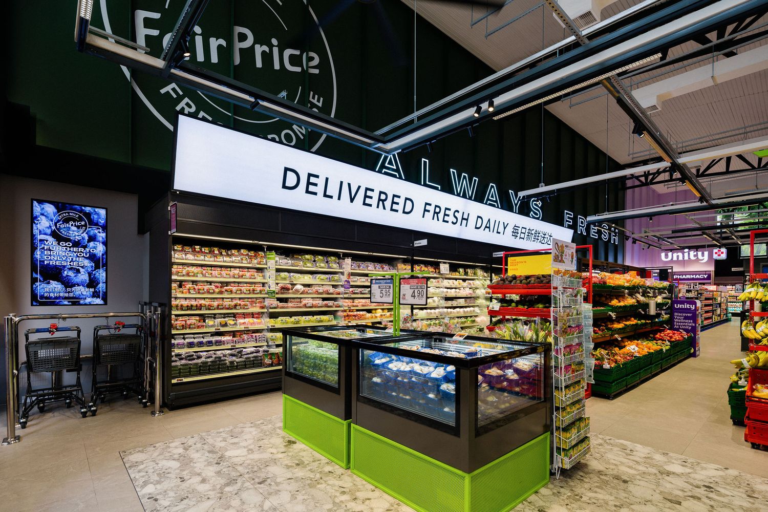 Modern supermarket interior with a Delivered Fresh Daily Always sign above refrigerated fresh food displays and colorful produce shelves.