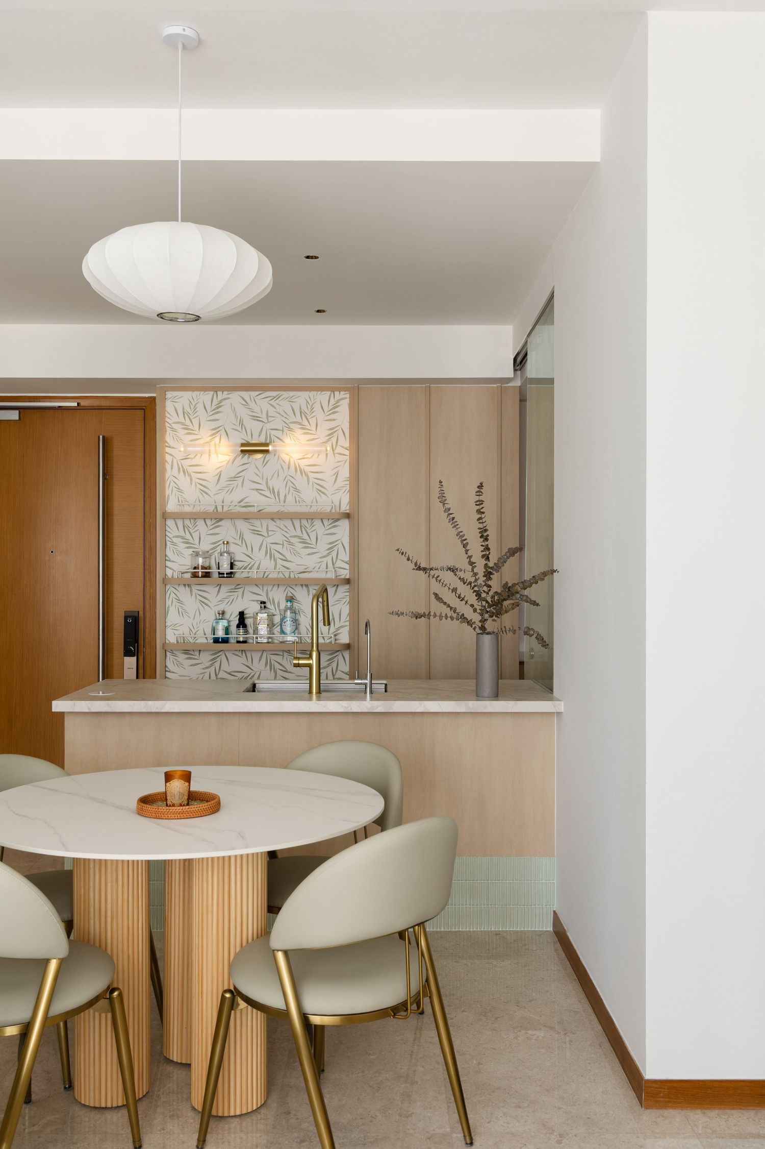 Contemporary dining area featuring a round white marble table with curved ivory chairs and modern pendant lighting.