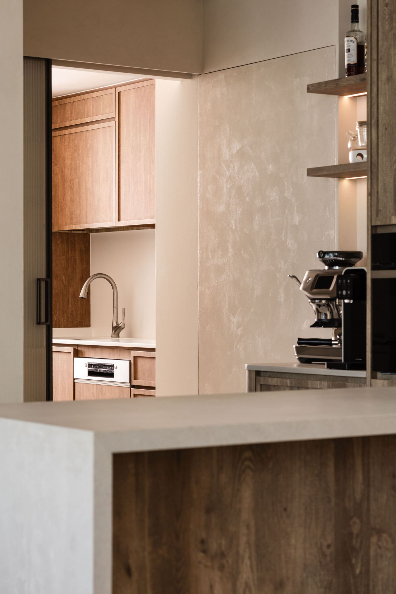 Modern minimalist kitchen interior with wooden cabinets and beige walls showcasing clean lines and contemporary design.