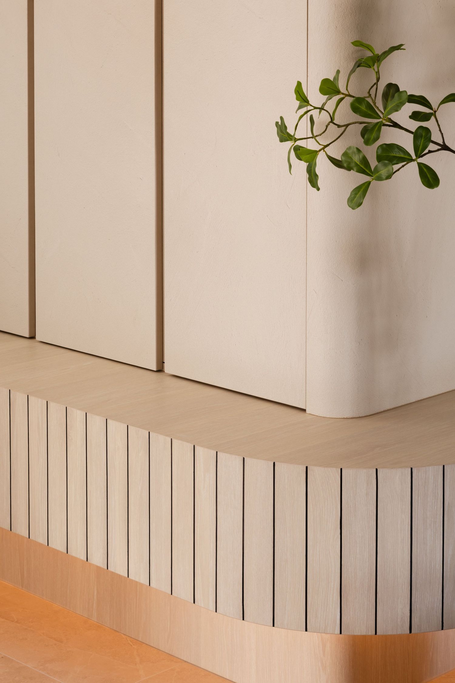 Modern white rectangular planters with green plants sit atop a beige surface against a white wall with vertical lines.