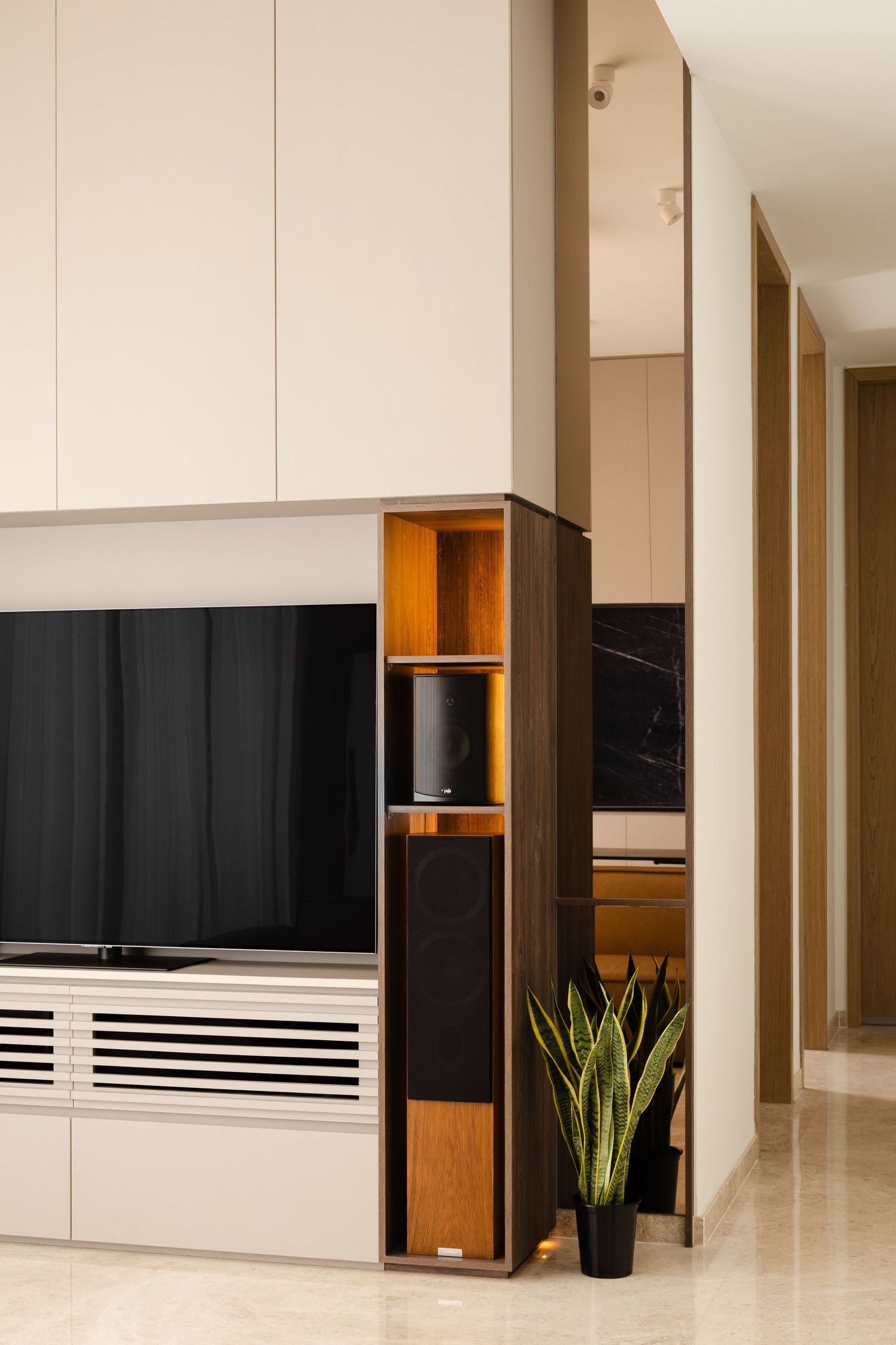 Modern apartment interior with white walls, wood accents, black panels and minimalist decor along a hallway design.