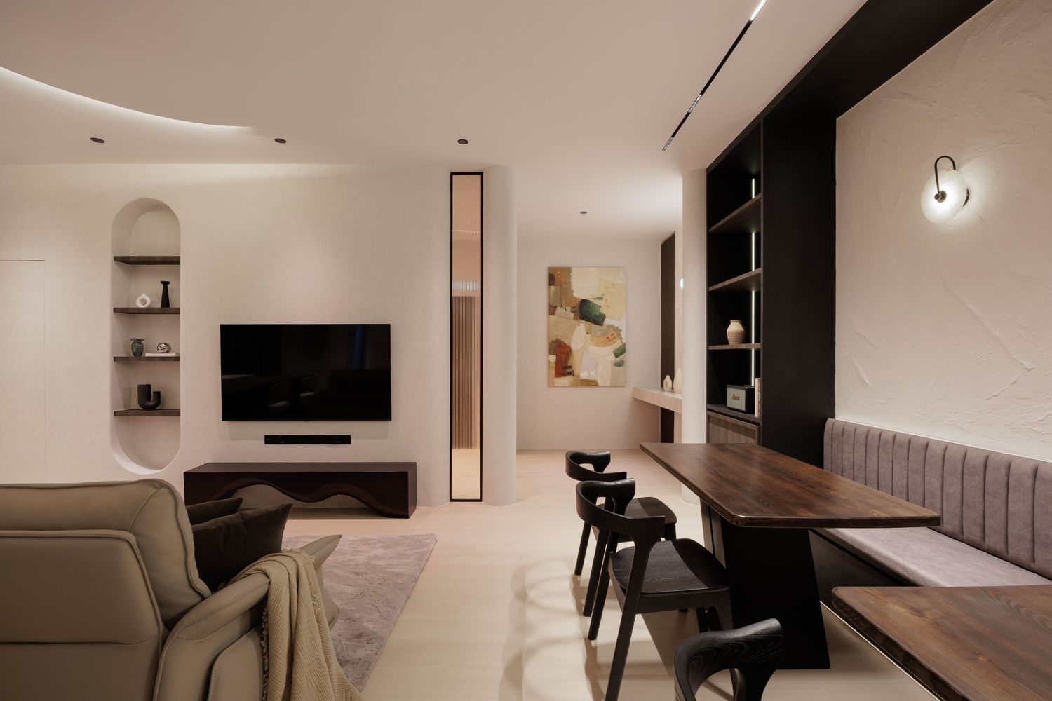 Modern minimalist living room features sleek furniture, neutral tones, and a wall-mounted TV in a bright interior space.